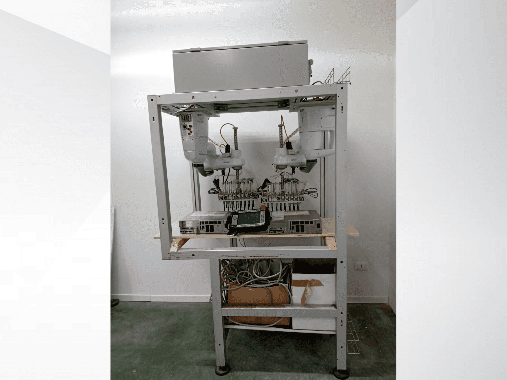 Automatiseeritud robottöökoht kahe käe, kuvamisseadme ja elektroonikaga metallraamil, esiplaanil, kõrgtehnoloogiline seadistus.