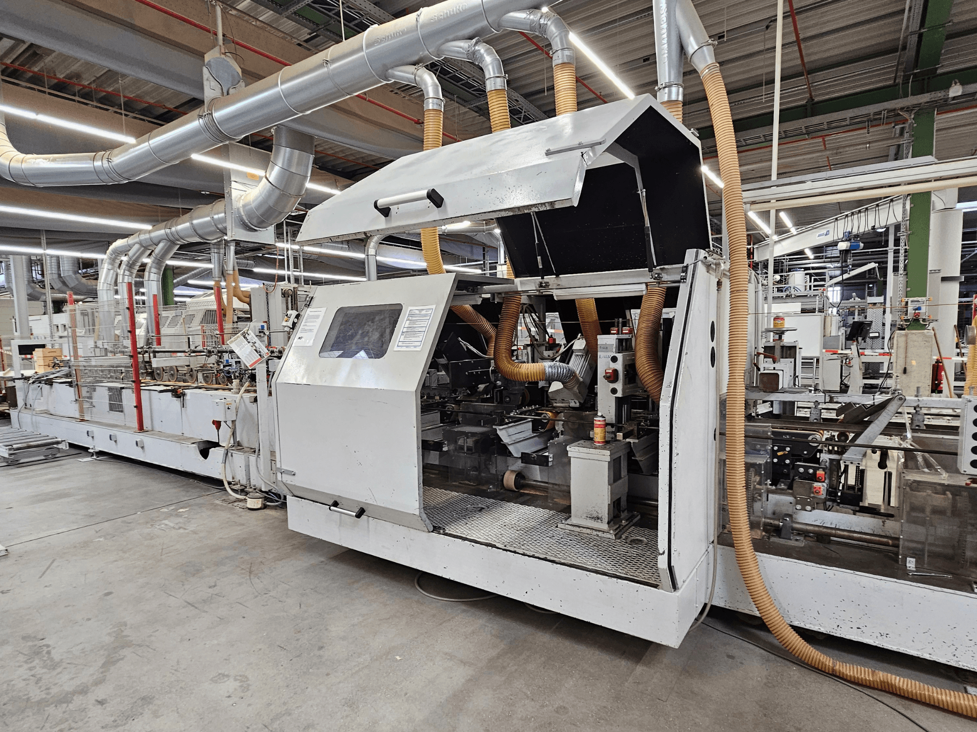 HOMAG FG63 servakandur tehases, külgvaates on näha töötavaid komponente ja tolmueemaldussüsteemi.