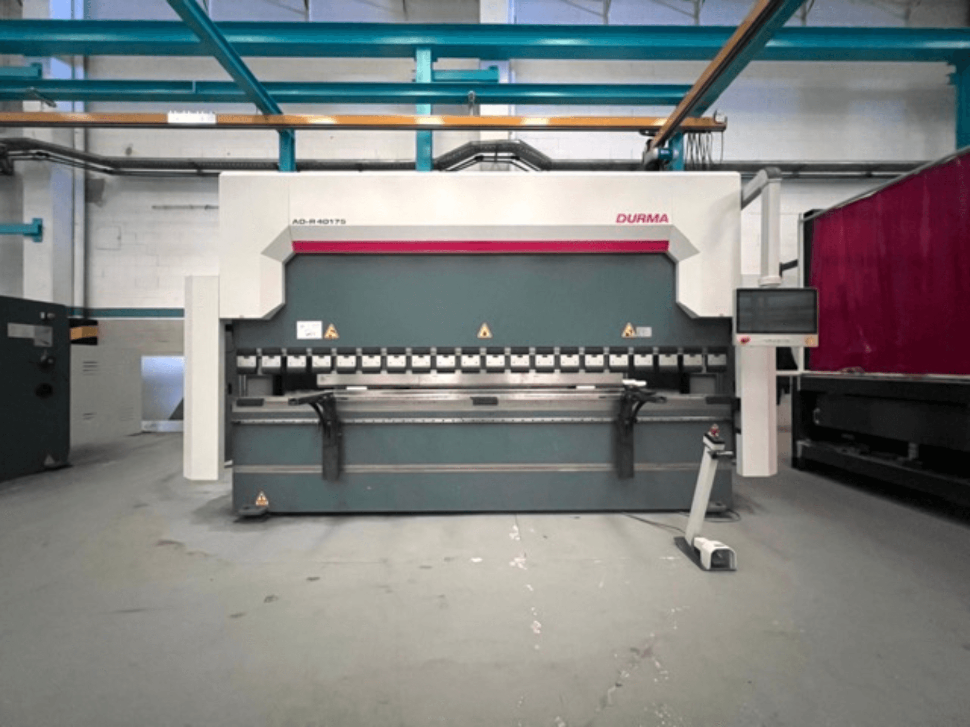 Durma AD-R 40175 presspink, esiplaanil, juhtpaneel ja mitu painutusmehhanismi töökojas.