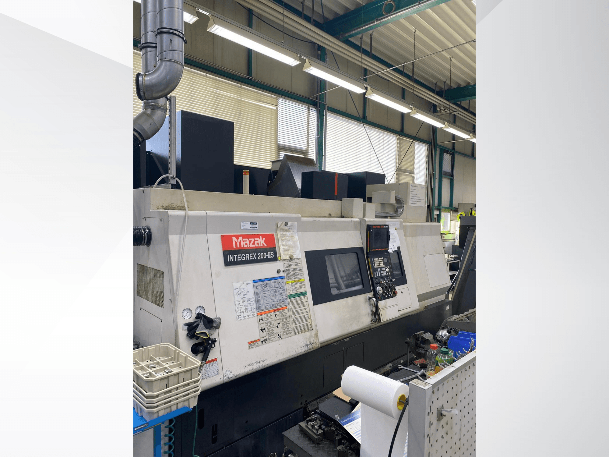 Mazak INTEGREX 200 III S treimis- ja freesimiskeskus, külgvaade, millel on näha juhtpaneel, mõõturid ja tööpinnal olevad tööriistad.