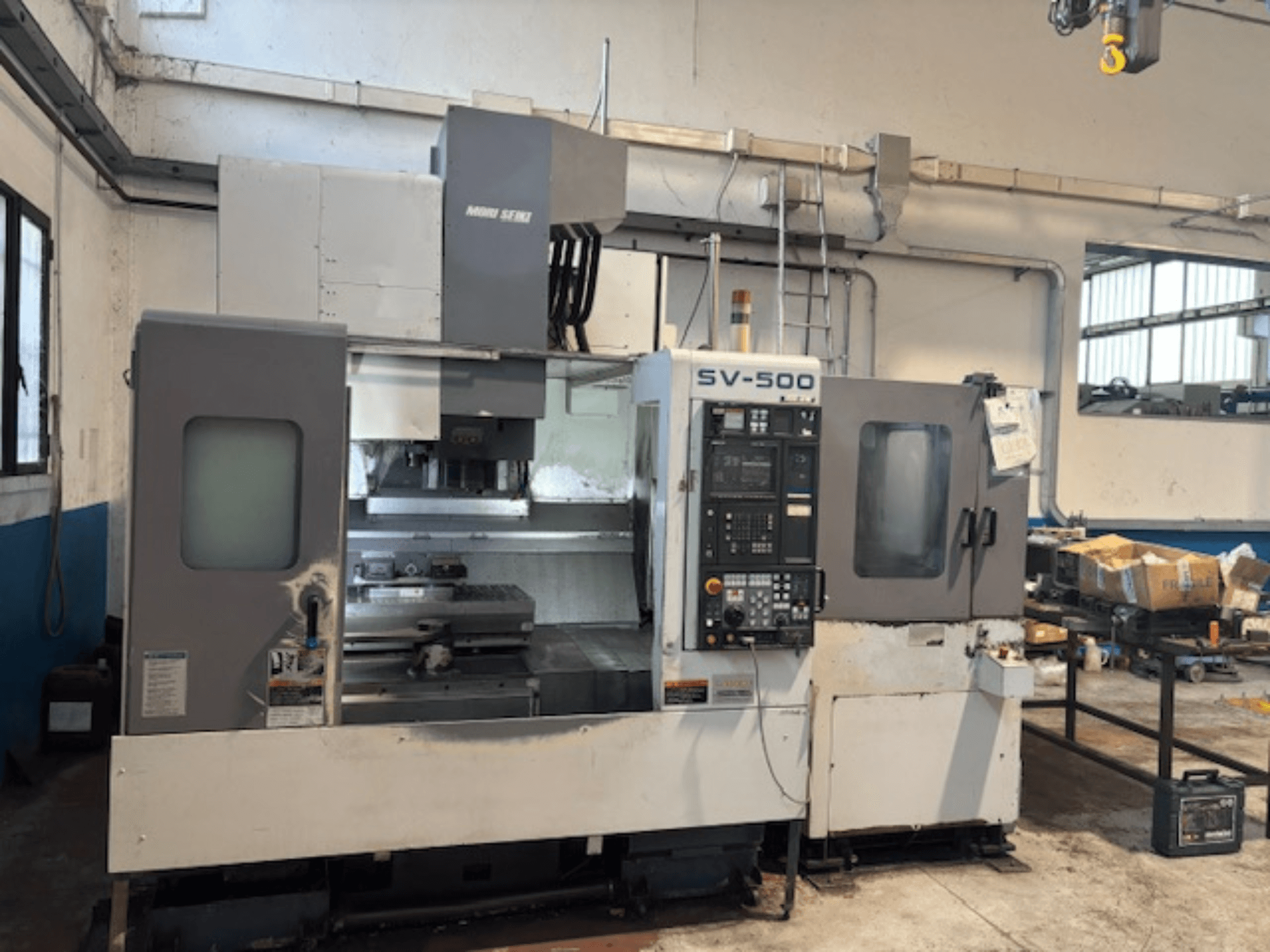 MORI SEIKI SV-500/40 vertikaalne töötluskeskus töökojas, esiplaanil on juhtpaneel ja töötlusala.
