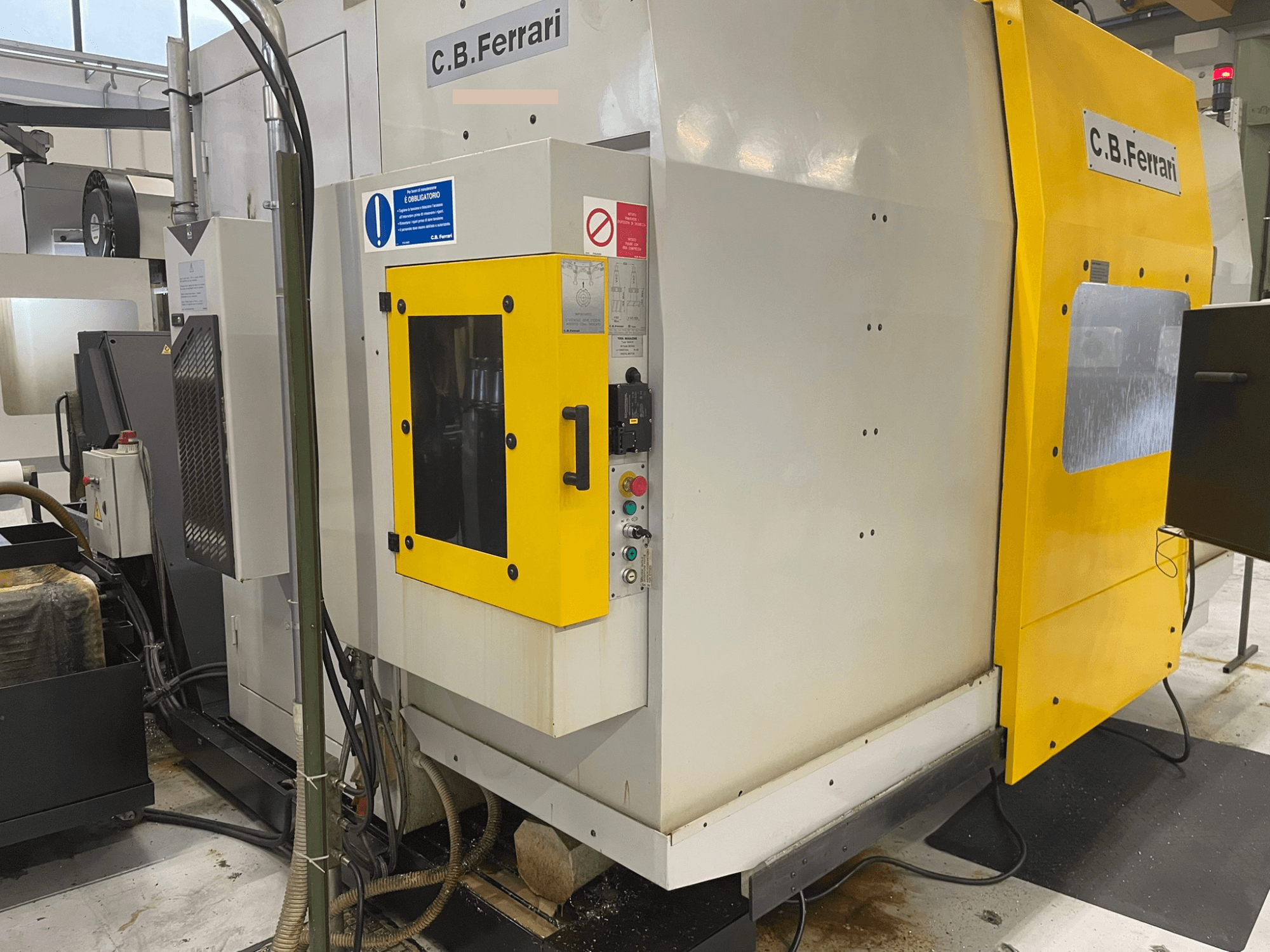 C.B. Ferrari tööstusmasin, esiplaan; kollane uks, juhtpaneel ja nähtavad mehaanilised komponendid.