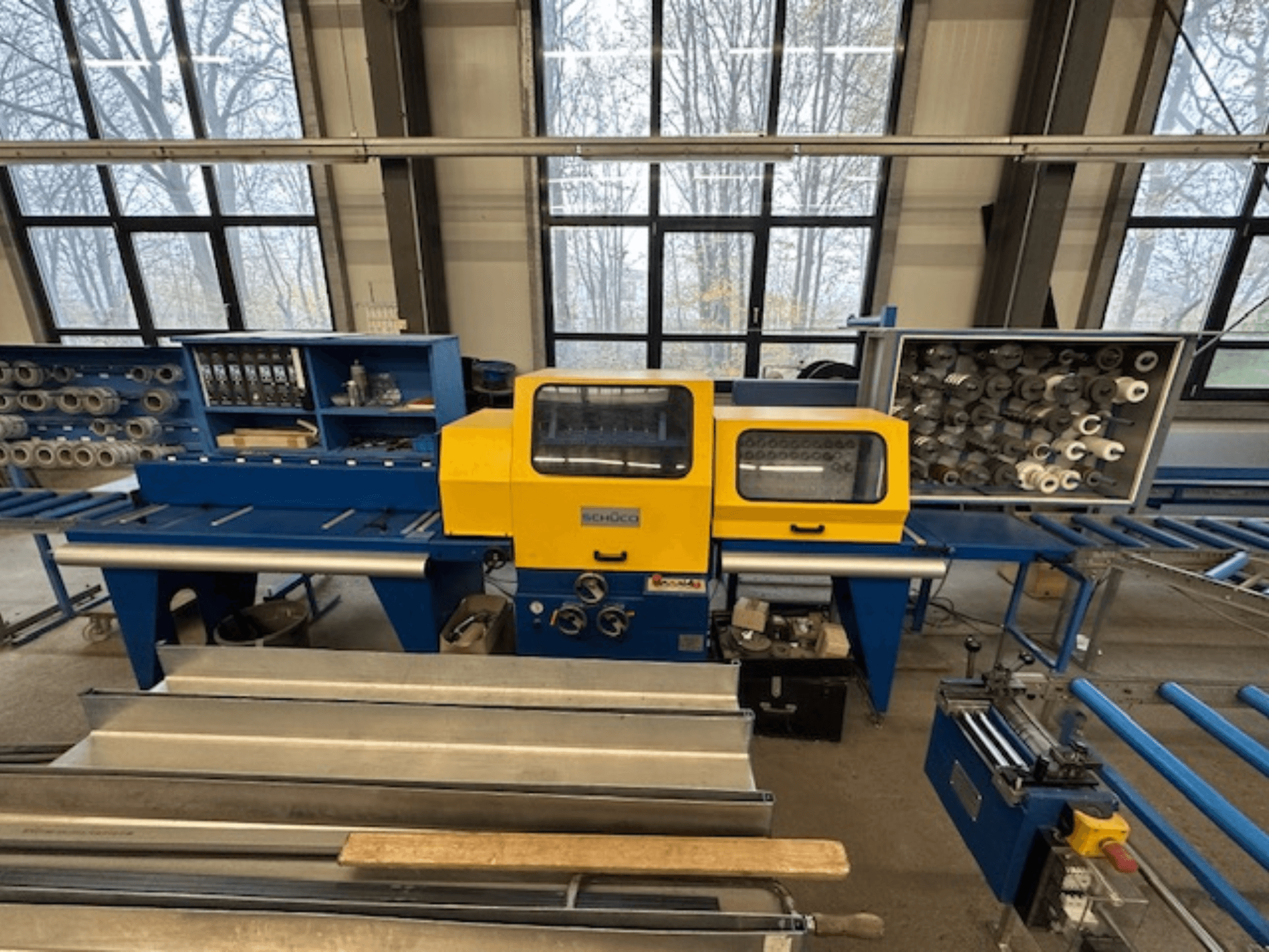 SCHÜCO ISOMAT 4 tööpinkide esivaade, millel on kollane juhtpaneel, mitu rulli ja hoiuruum.