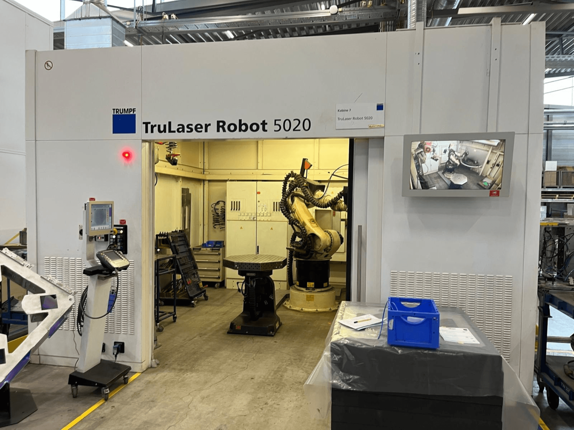 TRUMPF TruLaser Robot 5020 tööstuslikus keskkonnas, millel on juhtpaneel, robotkäsi ja operatsioone kuvav monitor.