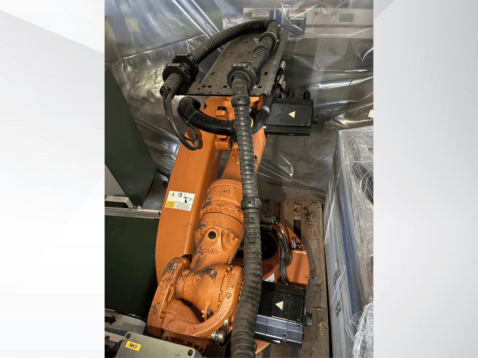 Oranž KUKA KR16-2 robotkäsi, vaadatuna ülalt, millel on näha ühendusdetailid ja kaitse torud.