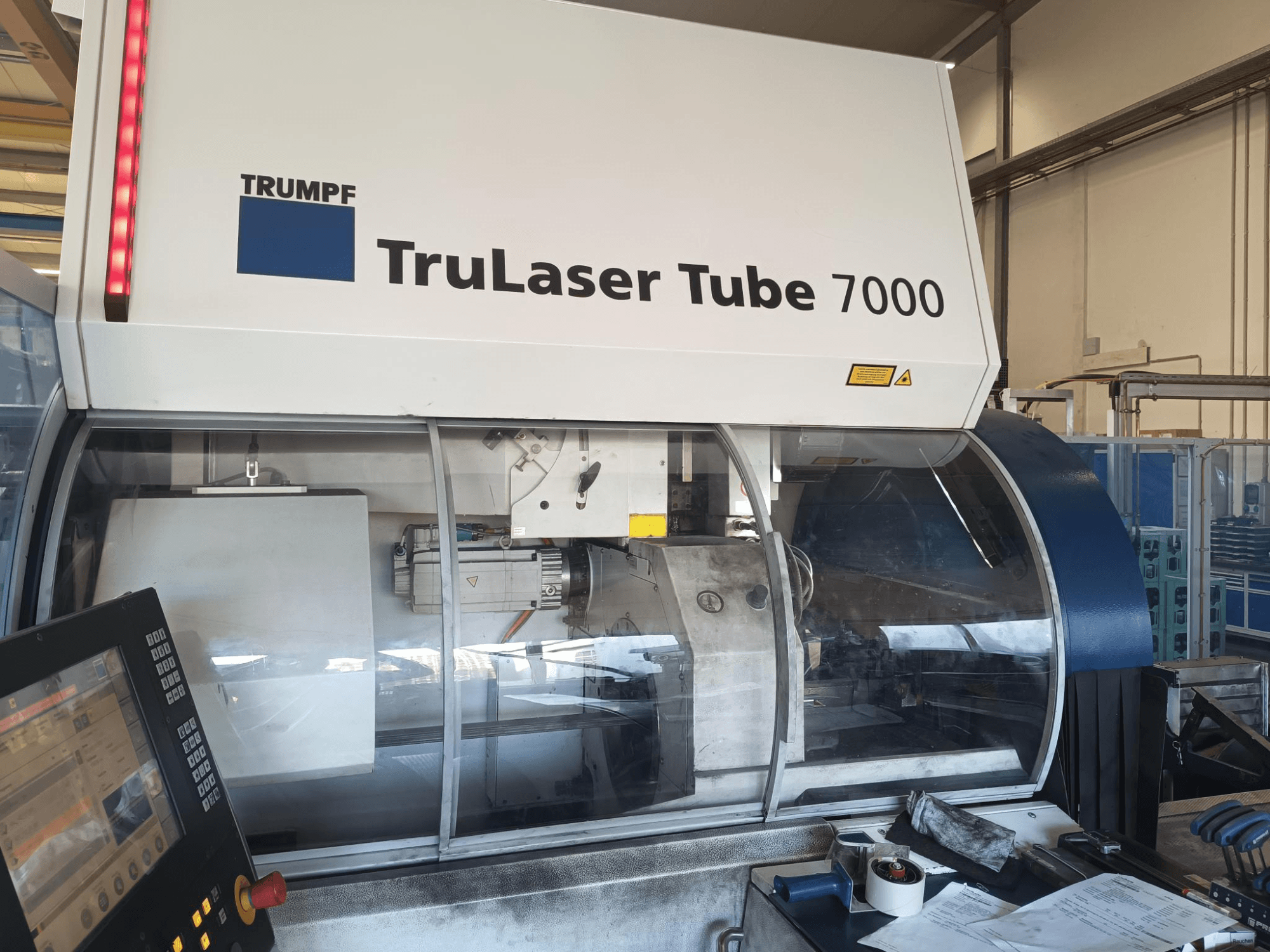 TRUMPF TruLaser Tube 7000, masina esikülg koos juhtpaneeliga, mis näitab laserlõikamise funktsioone ja tööruumi.