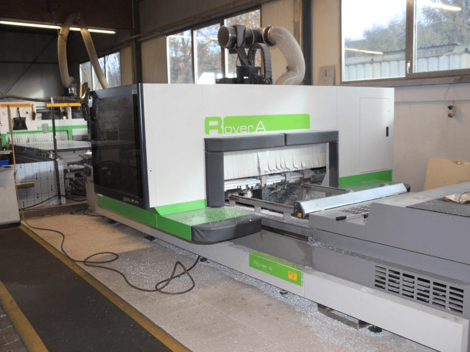 BIESSE Rover A 1232 CNC-freesüsteem, külgvaade, millel on näha lõikepind ja juhtpaneel tööstuslikus keskkonnas.
