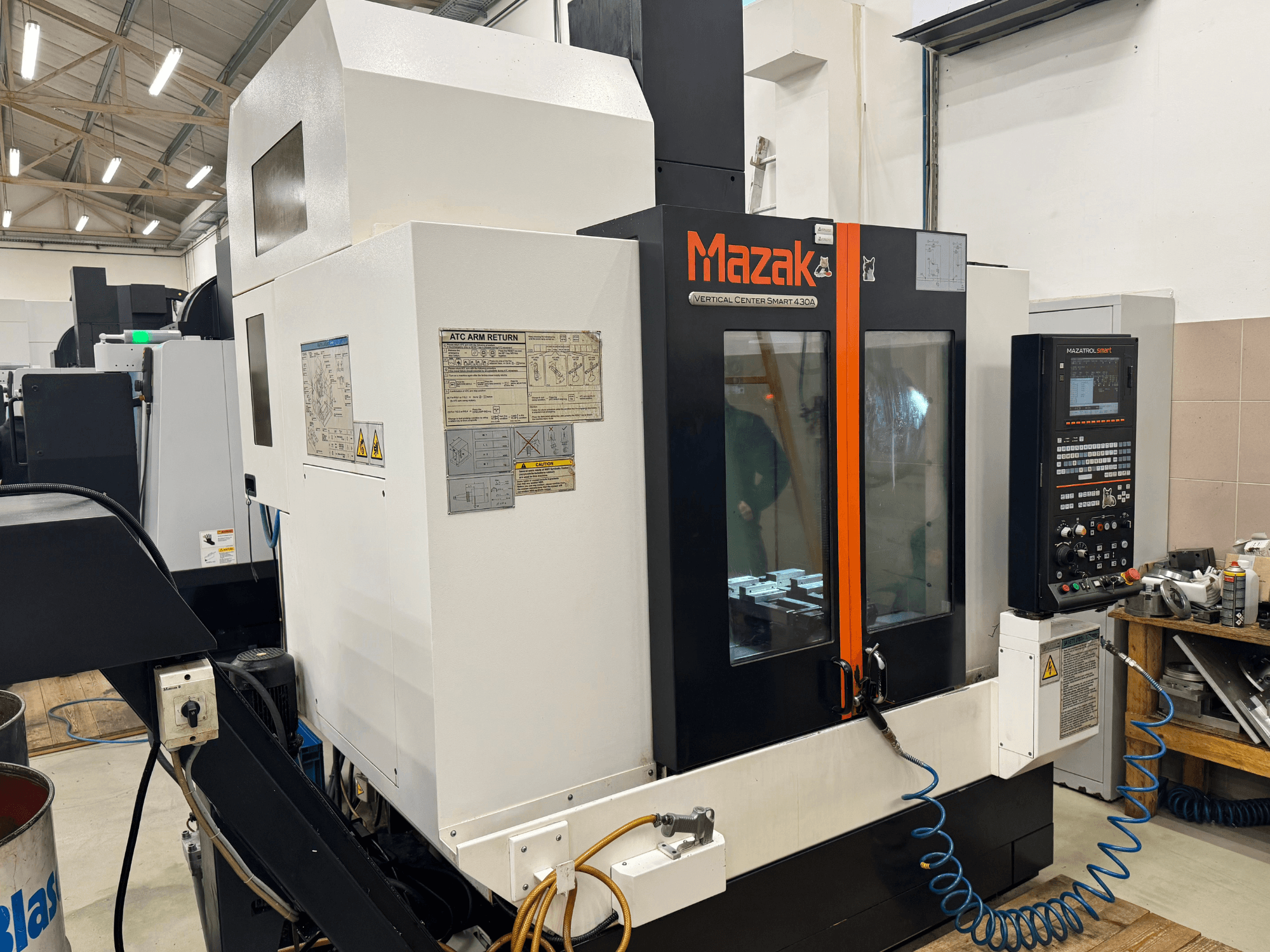 Mazak Vertical Center Smart 430A, esivaade; CNC-freesping, mille juhtpaneel, läbipaistev korpus ja tööriistahoidja on nähtav.