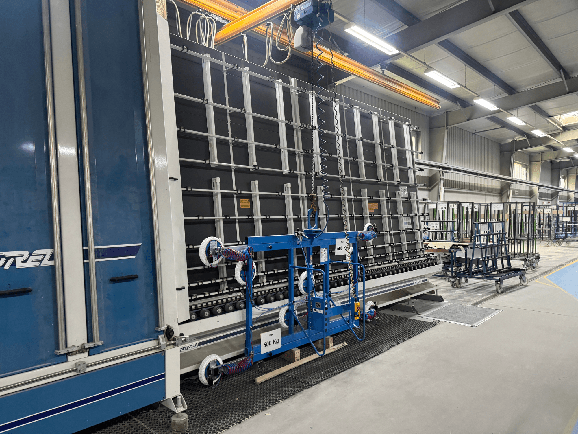 Dreli tööstusseadmed, millel on suur raam ja tõstemehhanism, näidatud külgvaates tehases.