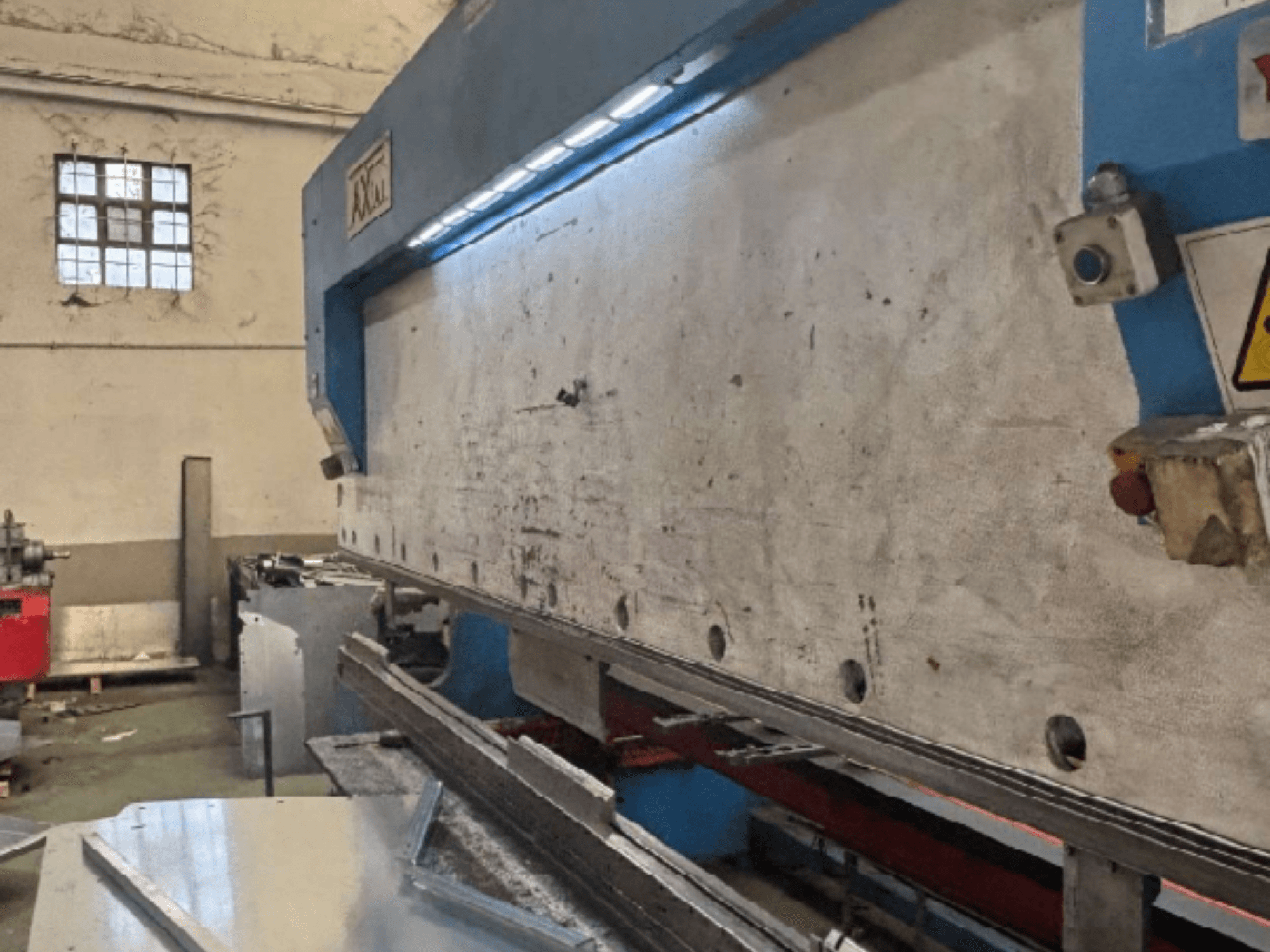 Axial PHS-W-124 kaubaaluste käitlemissüsteem töökojas, külgvaates on näha tööpinna ja juhtpaneeli üksikasjad.