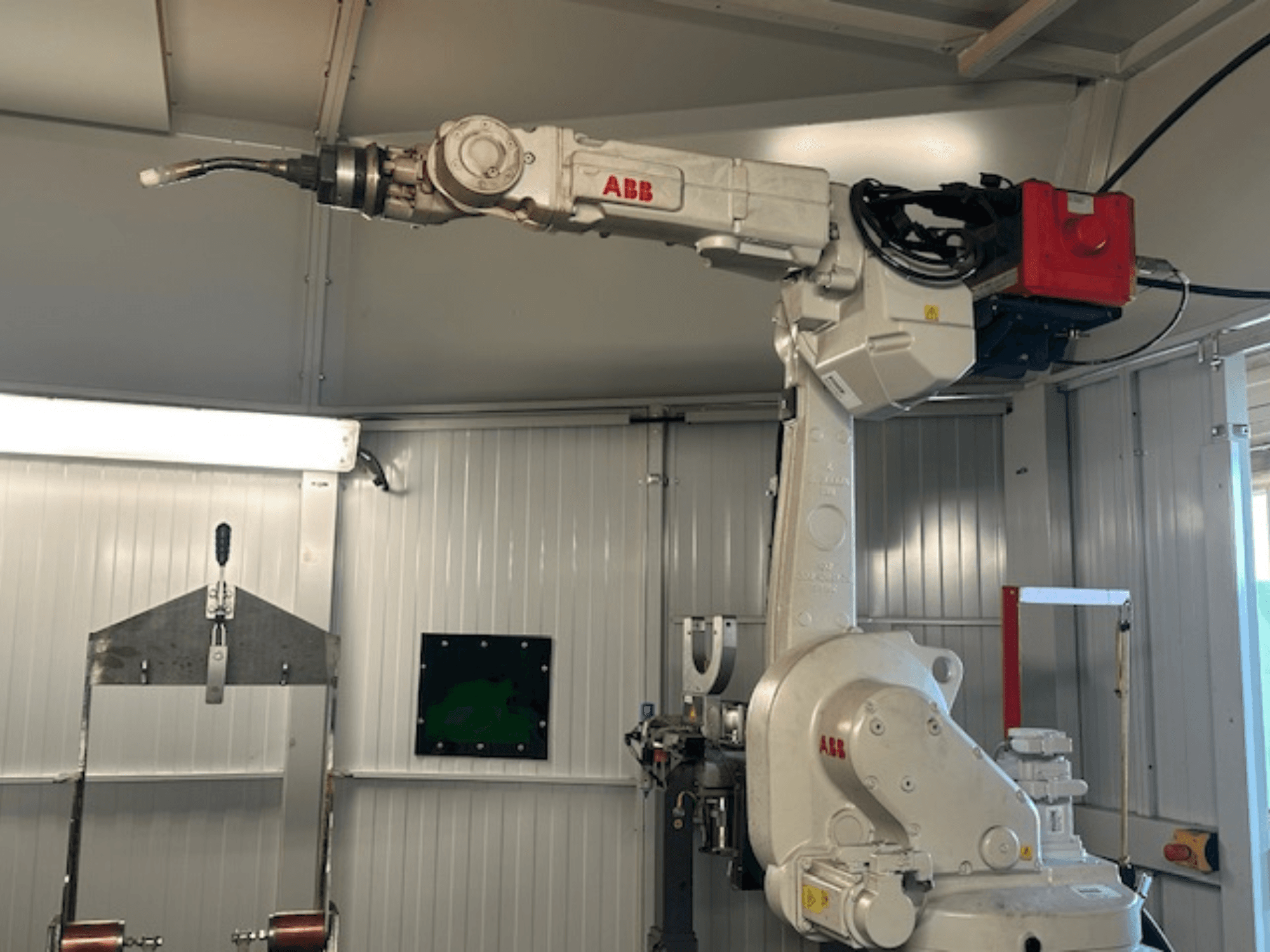 ABB Schweißroboter Flex Arc - robotkäe külgvaade koos keevitusseadmega, kus on näha selliseid detaile nagu juhtpaneel ja kaablid.