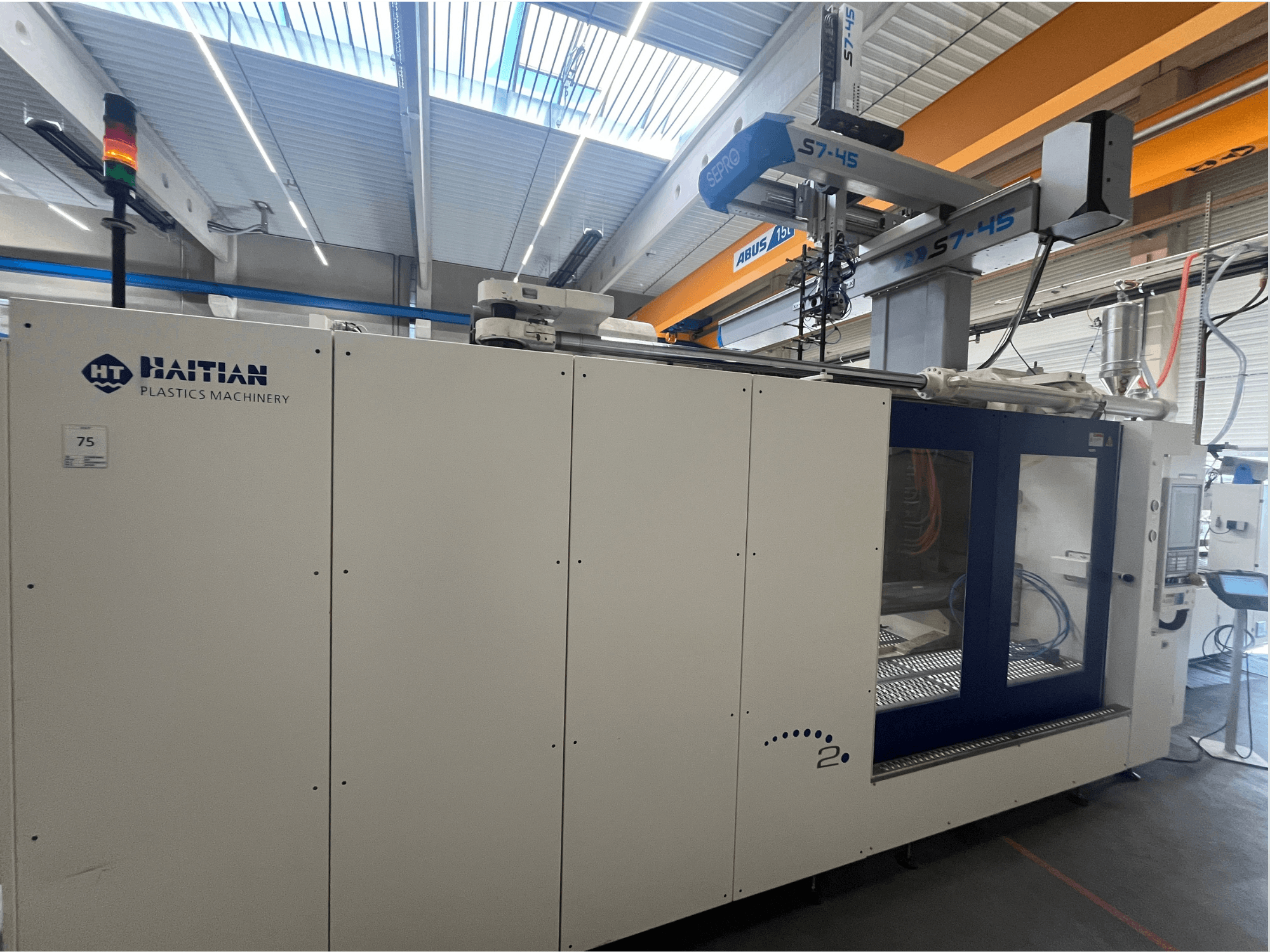 Haitian S7-45 survevalu masin külgvaates koos juhtpaneeli ja turvavalgustuse indikaatoriga. Valge ja sinine disain.