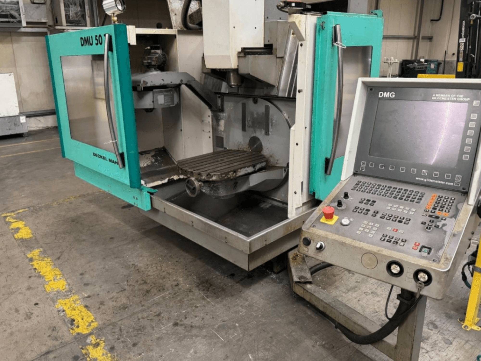 DMG DMU 50 freespink avatud ustega, kus on näha sisemus ja juhtpaneel, vaadatuna eestpoolt.