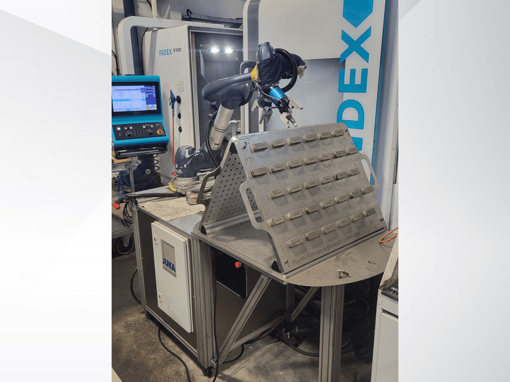 Koostöörobot DOOSAN M1013 esiplaanilt, mis on paigutatud töölaua lähedale koos tööriistahoidiku ja juhtpaneeliga.