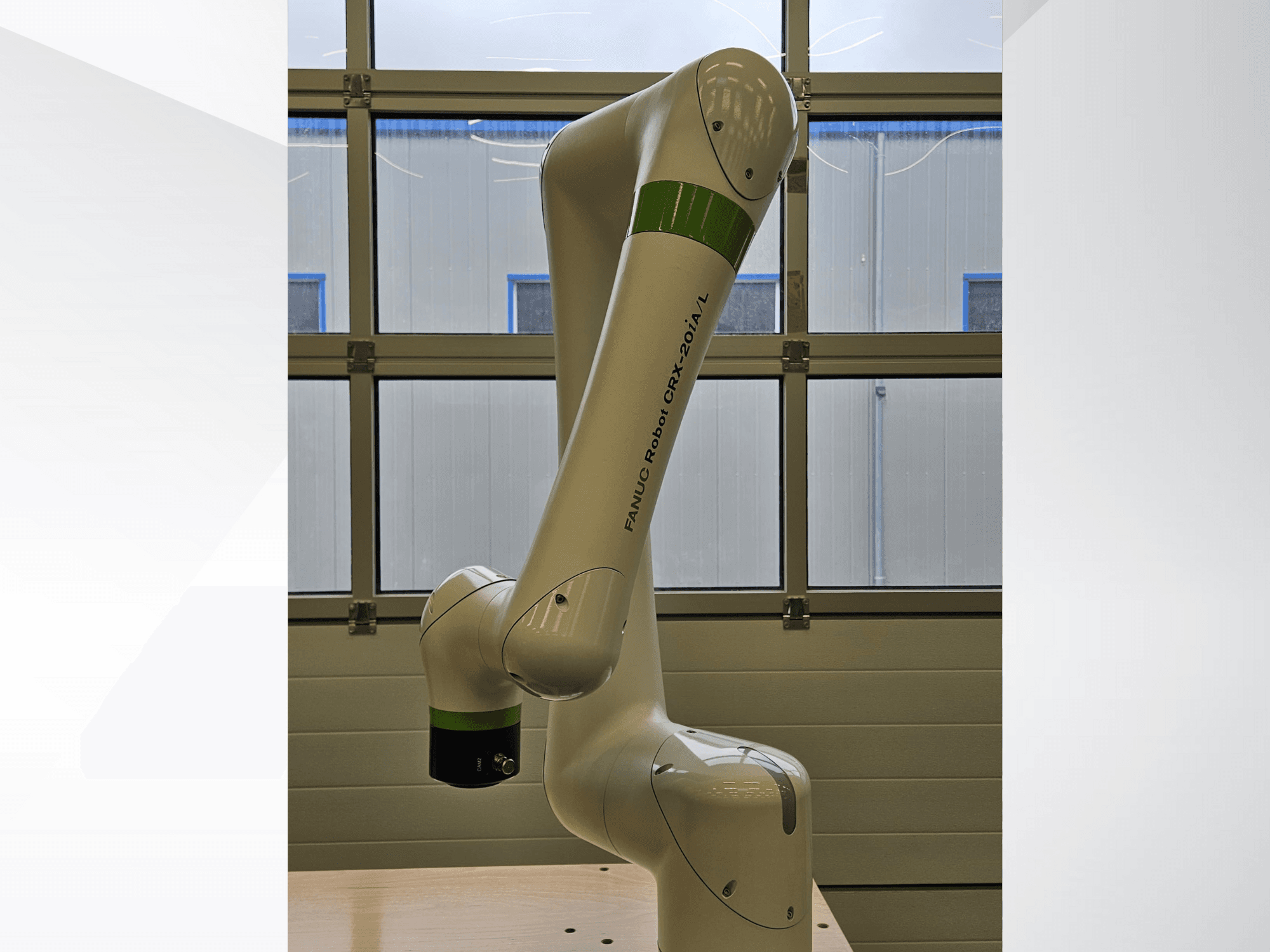 FRANKA ROBOT CRX-20A/L, külgvaade, kus on näha selle liigendkäsi ja roheline ja must haarav otsaefektor.