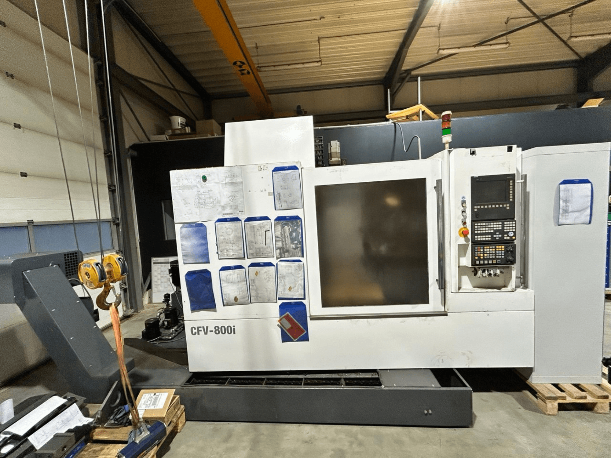 CFV-800i CNC-masin esiplaanil, juhtpaneel, dokumendid küljel ja kraana tehase seadistuses.