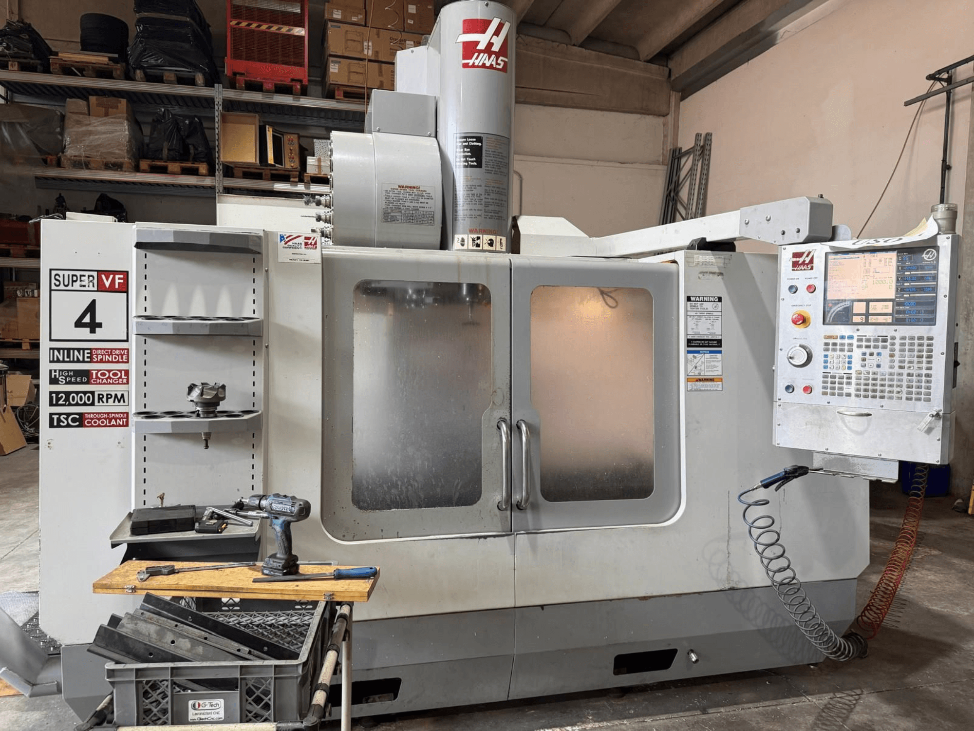 HAAS VF-4SSHE vertikaalse töötlemiskeskuse vaade eest, millel on juhtpaneel, tööriistade hoidik ja 12 000 RPM pöörlev spindel; kiire ja täpne masin.