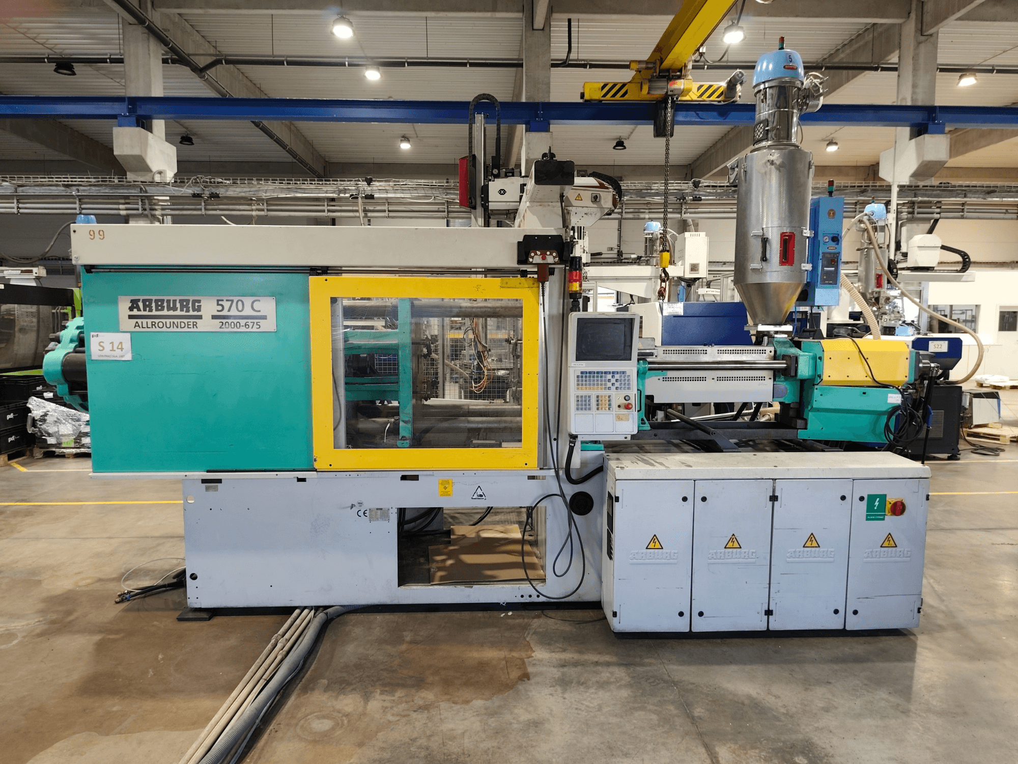 Hüdrauliline survevalumasin Arburg Allrounder 570 C 2000-675, vaade eest, millel on juhtpaneel ja materjalimahuti.