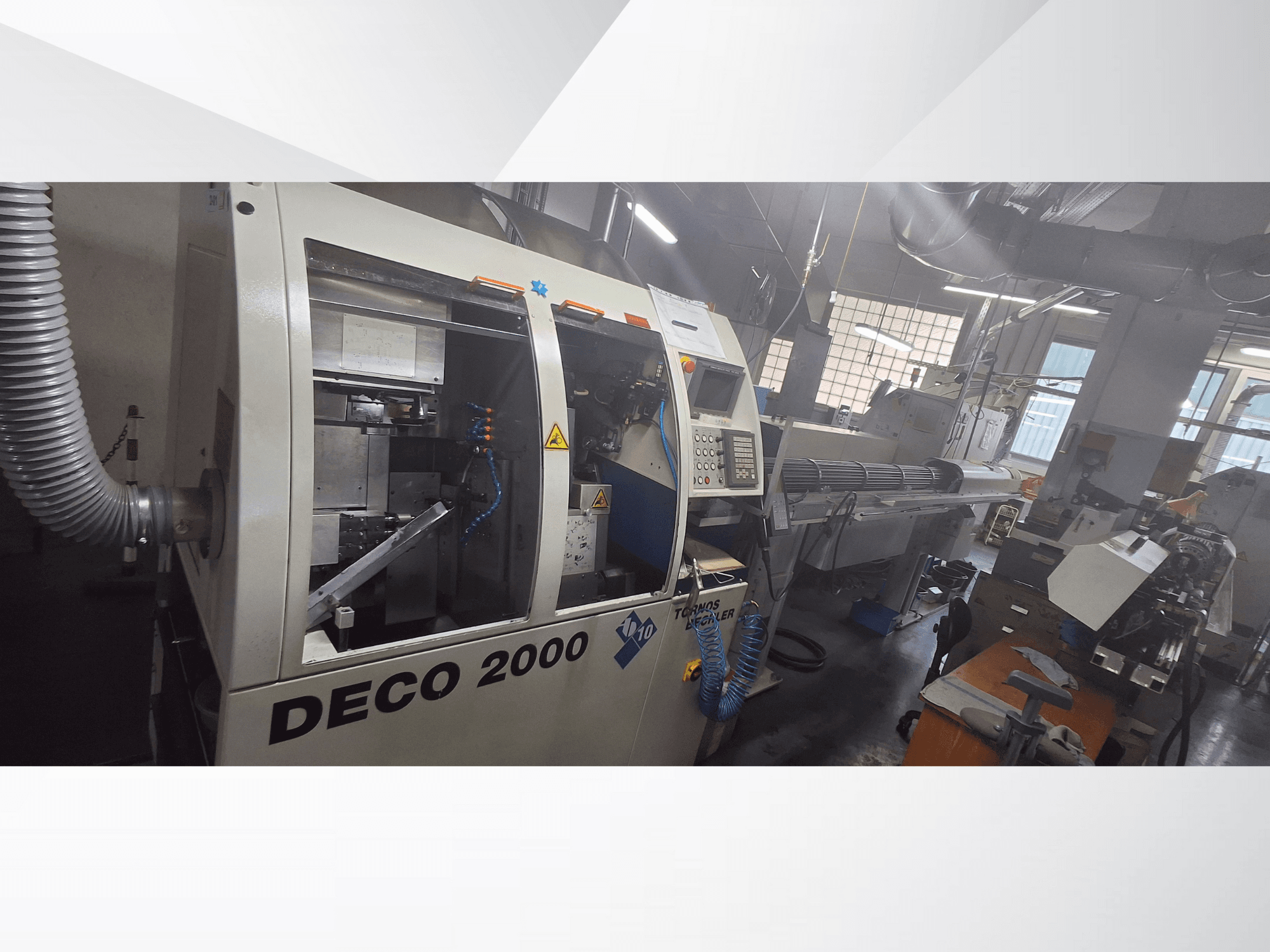 DECO 2000 CNC-tööpink töökojas, esivaade, kus paremal on näidatud juhtimisseadmed ja pikk tööpinkide seadistus.