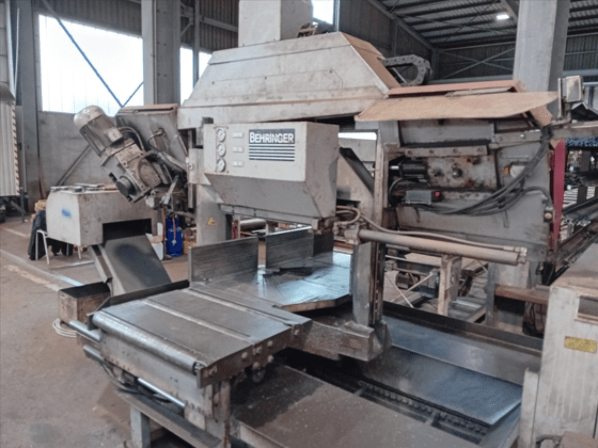 Behringeri vöösaag, esiplaanil, suure tera, mootori ja reguleeritava lauaga, mis sobib ideaalselt metalli lõikamiseks töökojas.