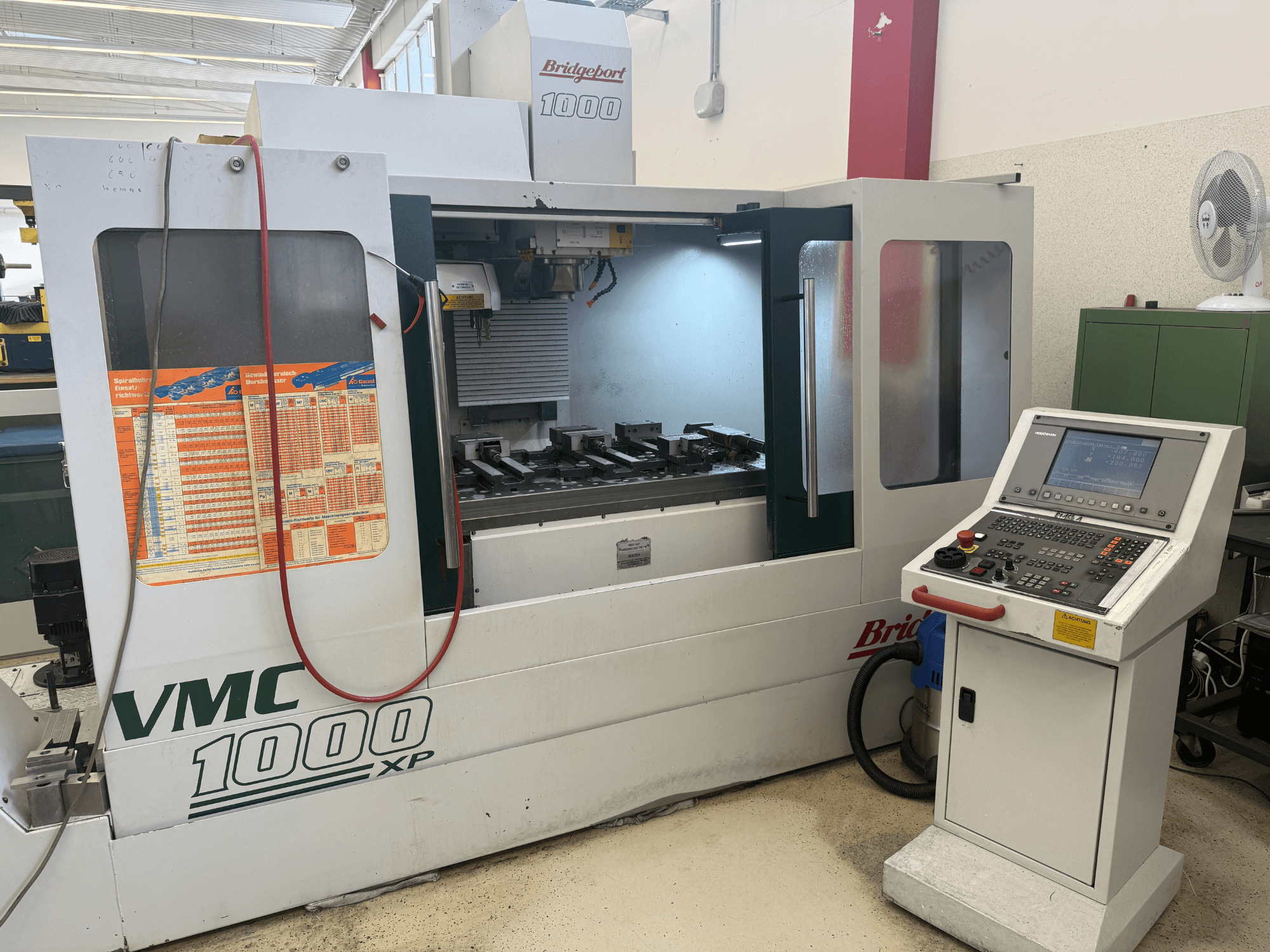 Bridgeport VMC 1000 XP vertikaalse töötlemiskeskuse esivaade, millel on näha juhtimispaneelid, töötsoon ja tööriistade kinnitused.