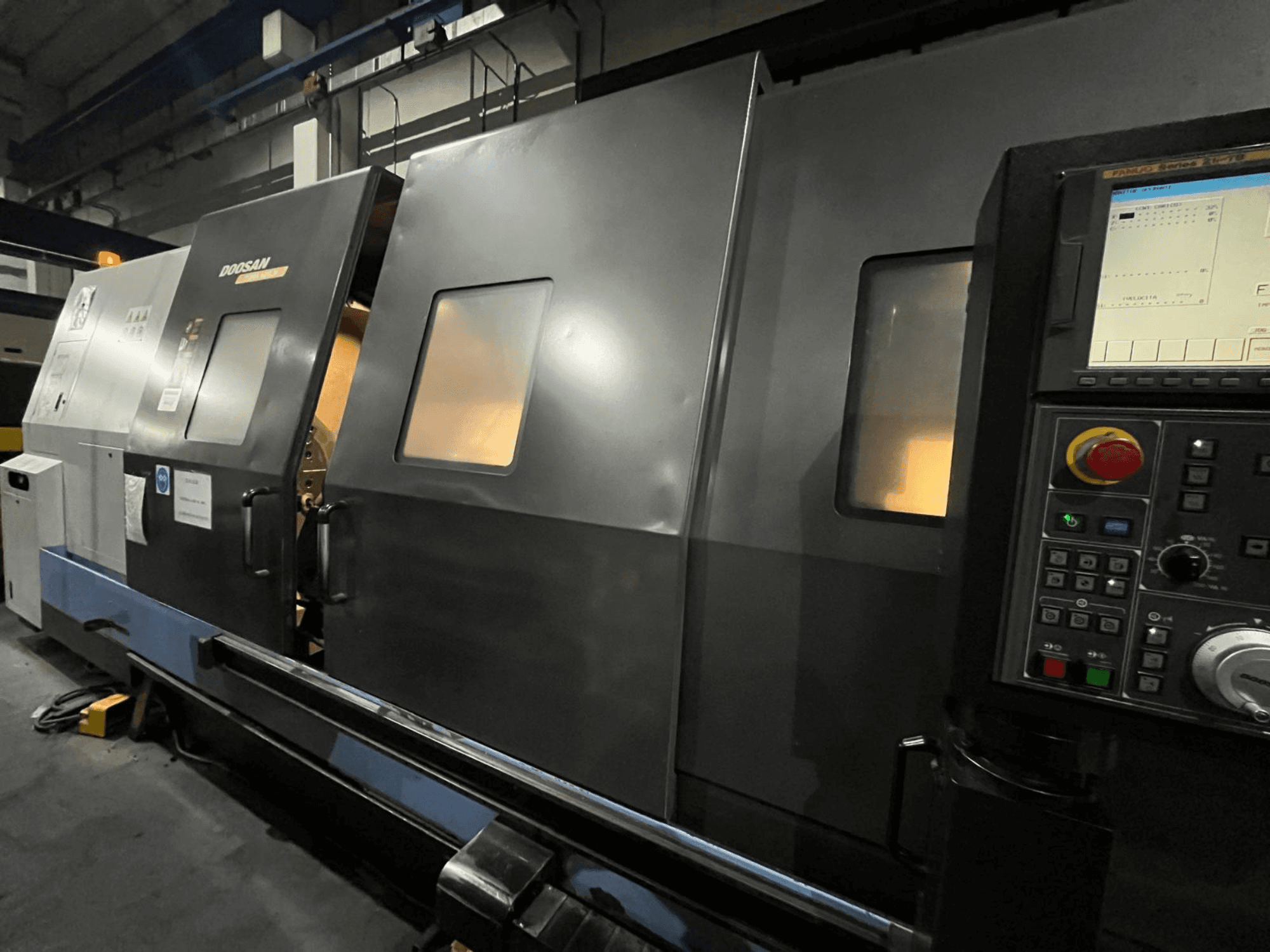 Doosan CNC-treipink eesvaates, millel on juhtpaneel ja operaatori kasutajaliides koos nähtava digitaalse ekraani ja nuppudega.