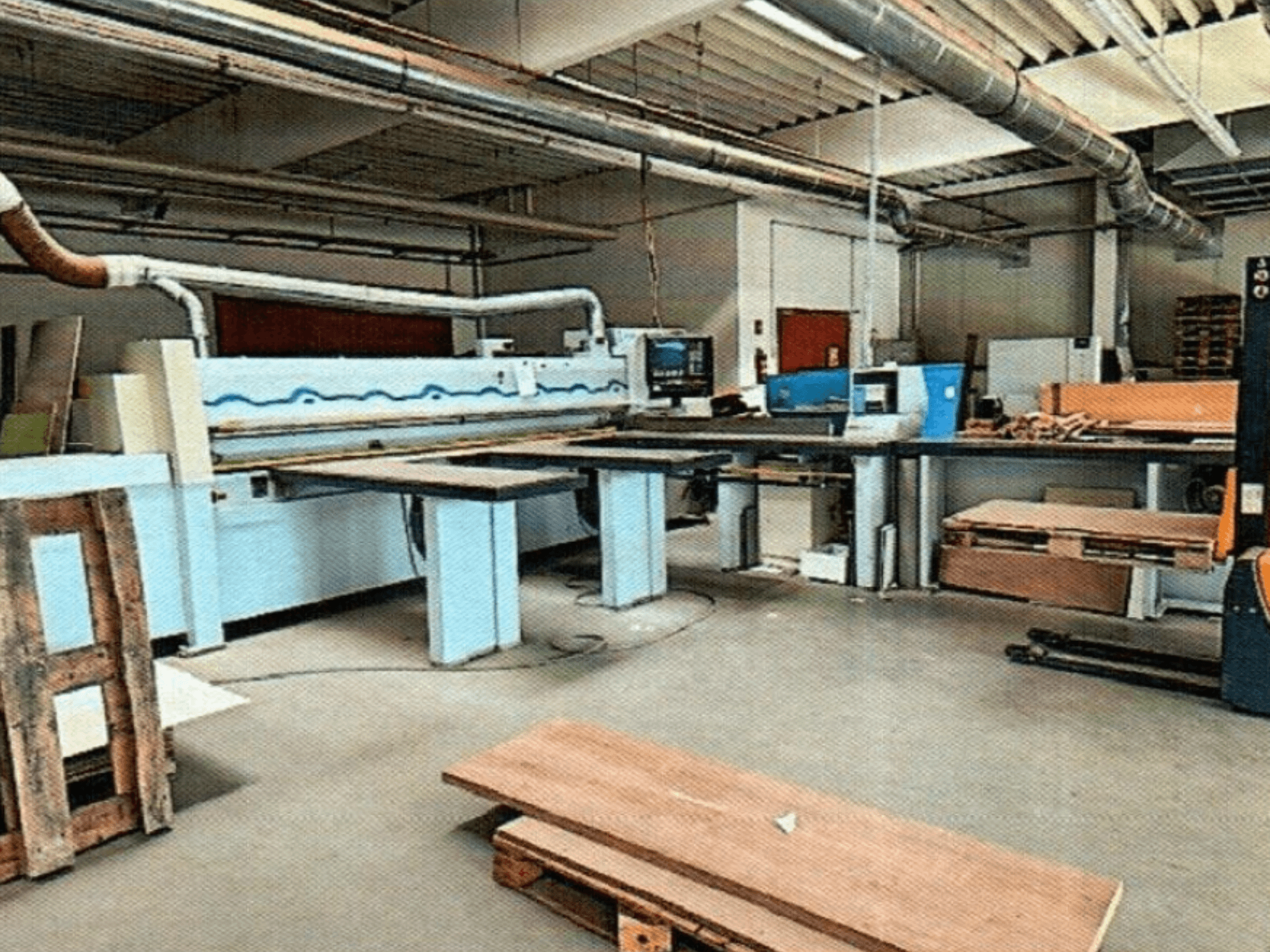 HOMAG HPL 11/38/22 plaadisaag töökojas, kus on suur lõikelaua ja näidiskonsool, esiplaanilt vaadatuna.