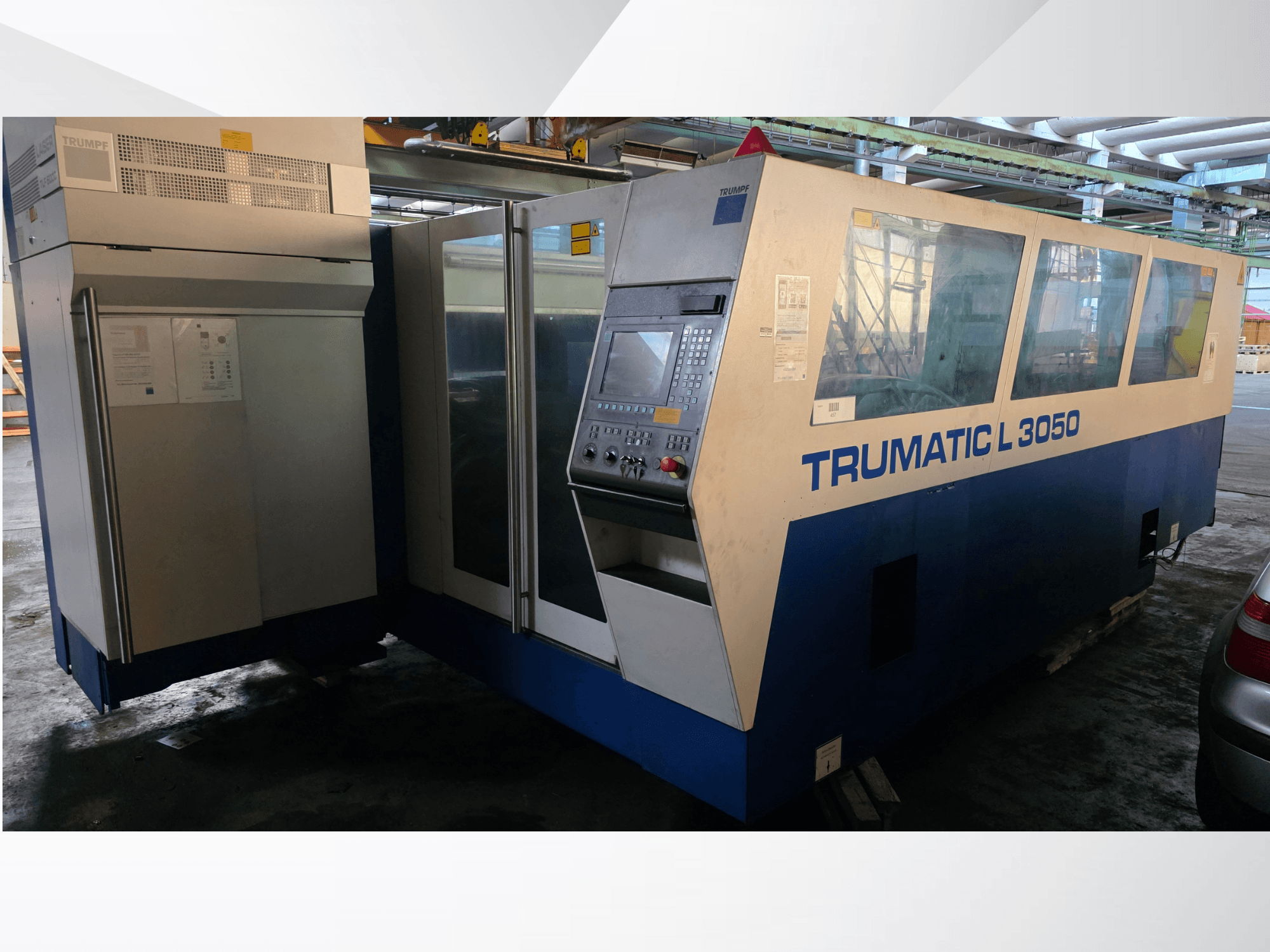 TRUMPF Trumatic L 3050 CO2-laserlõikepink, esiplaanil, juhtpaneel ja suured klaasaknad.