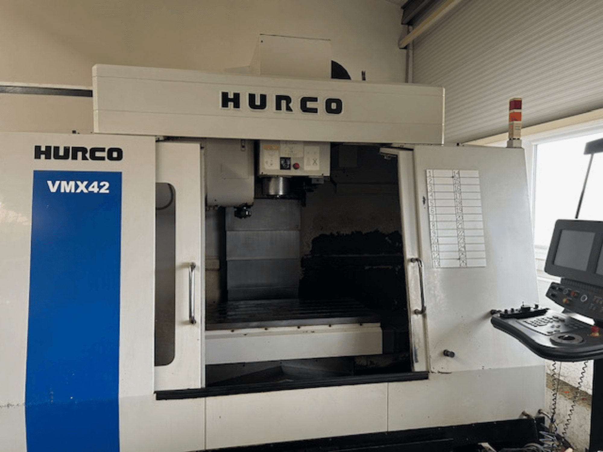 Hurco VMX42 CNC-tööpink eesvaates, kus on näidatud juhtpaneel, spindel ja tööpiirkond; ilmneb tööplaan.