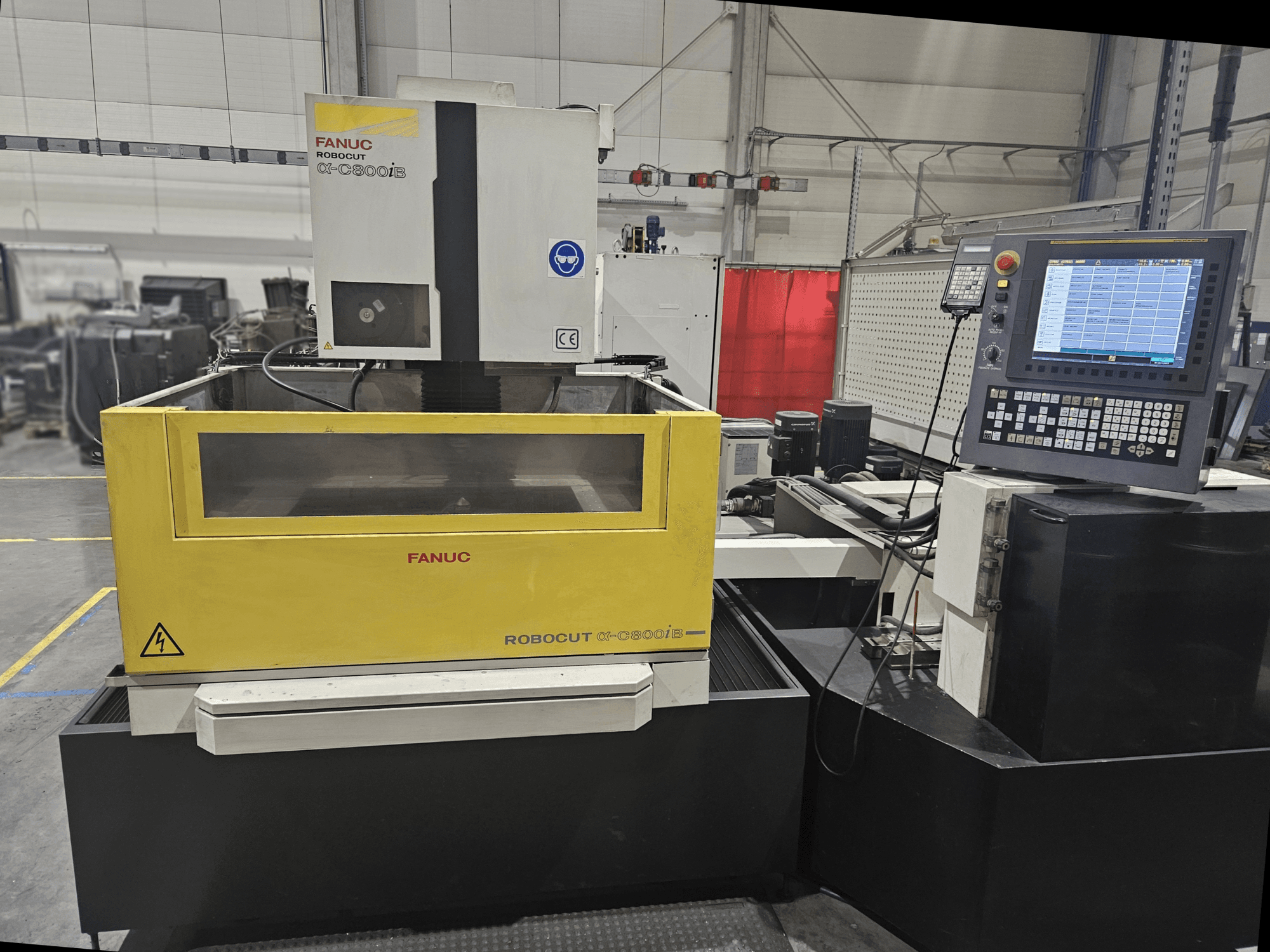 FANUC Robocut α-C600iB esiplaanil kollase ja halli masina korpuse, CNC-juhtimispaneeli ja töötava ekraaniga.