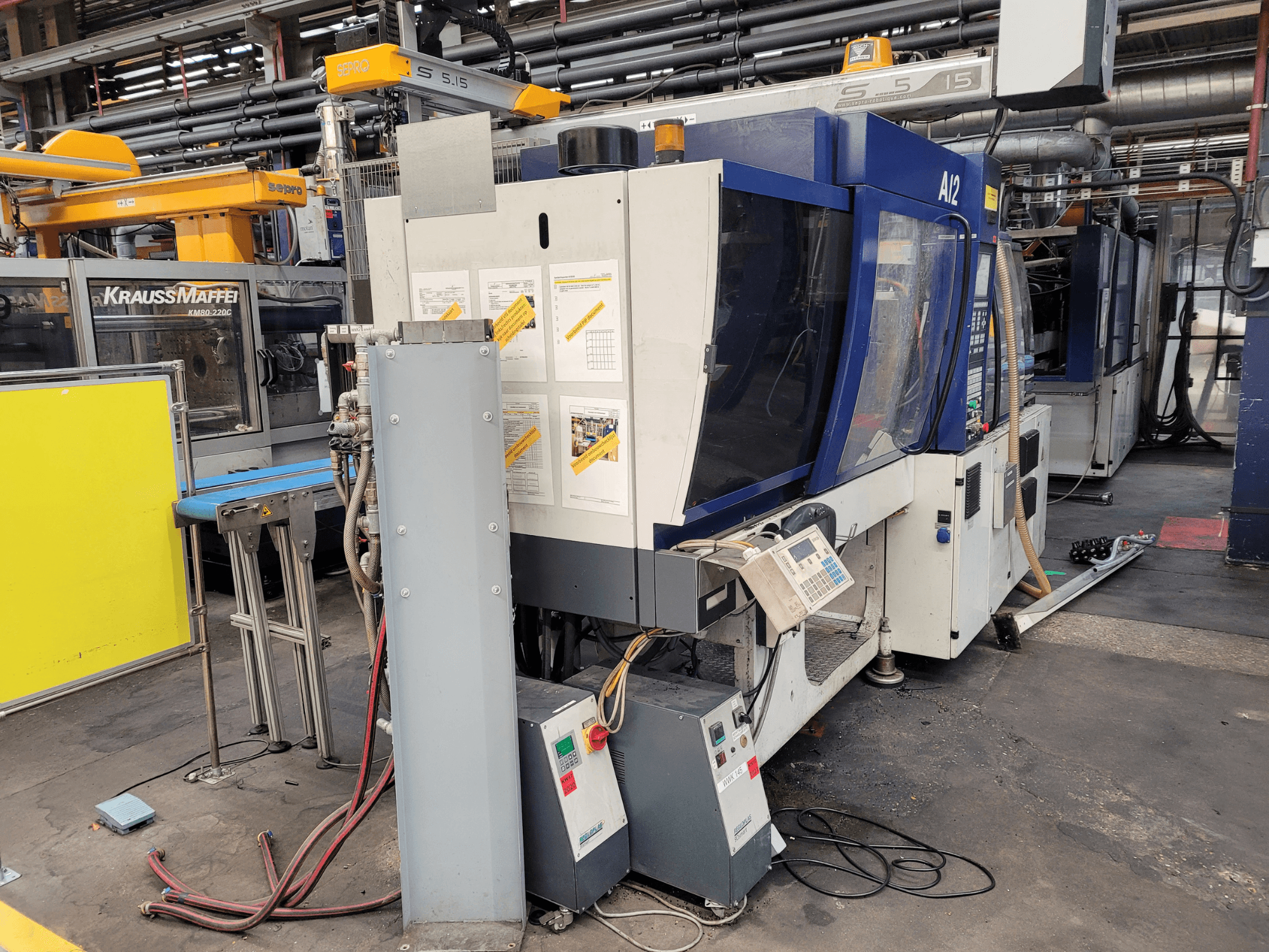 KraussMaffei survevalu masin mudel KM80-232G, esiplaanil, juhtpaneel ja tööorganid.