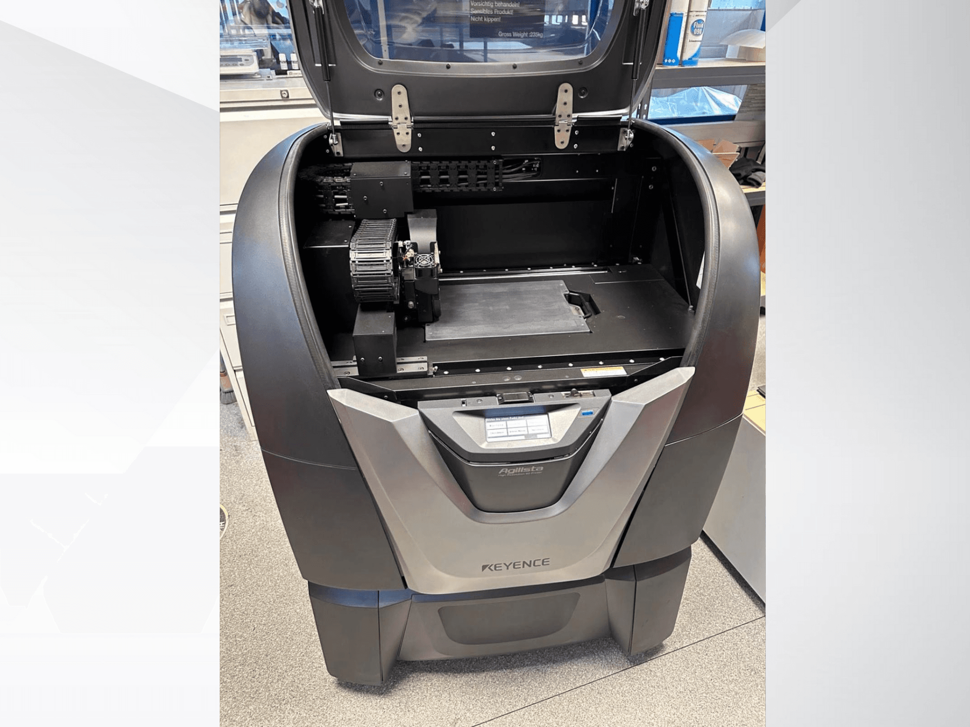 KEYENCE Agilista 3D-printer, esivaade, paljastab avatud ülemise osa, suure ehitusplatvormi ja sisemised mehaanilised komponendid.