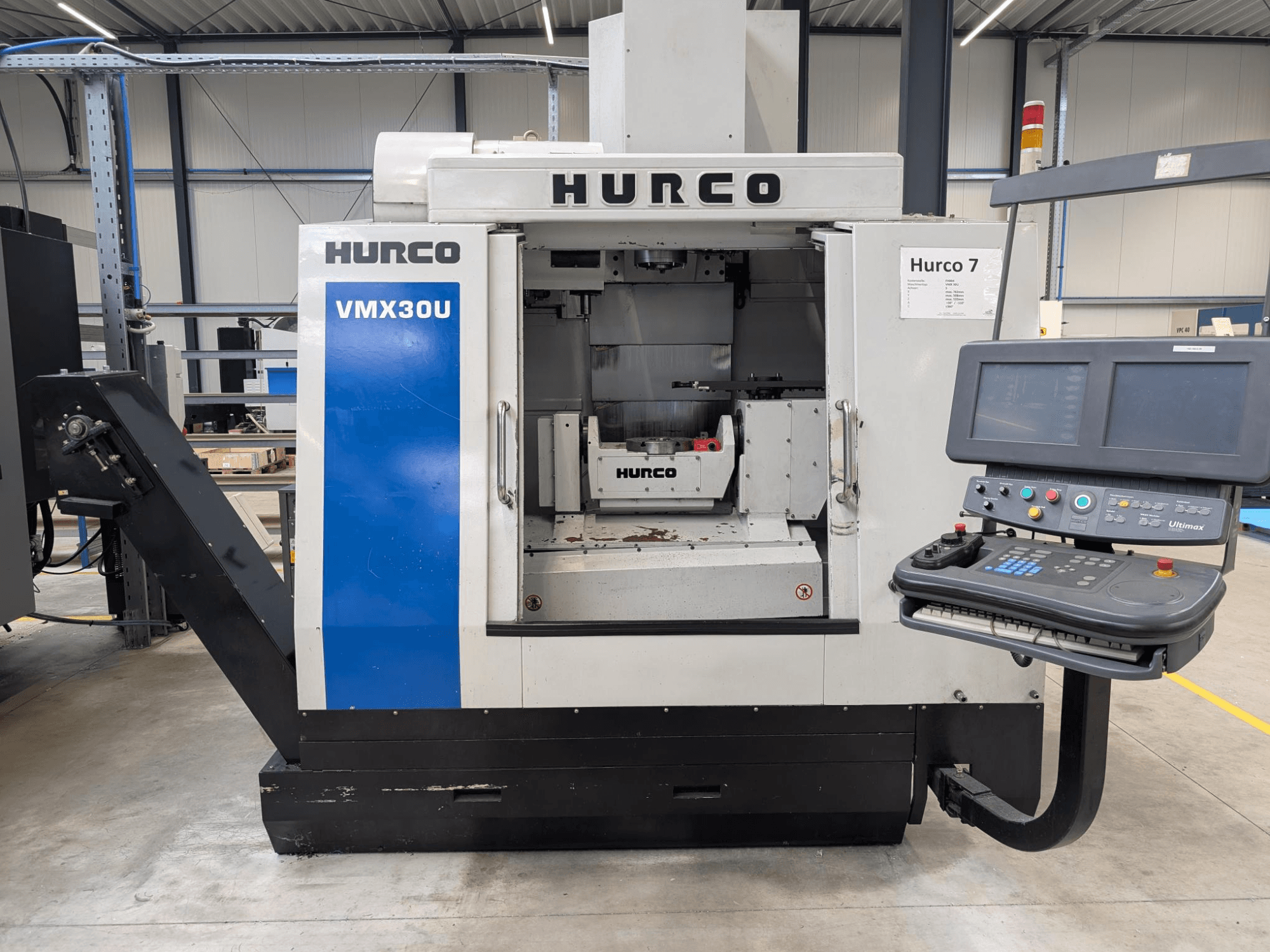 Hurco VMX30U CNC-tööpink eesvaates koos juhtpaneeliga; mahukas sisemus ja täpne juhtimisliides.