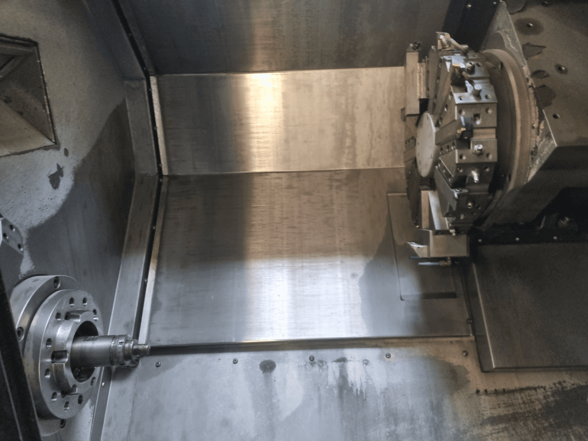 Tööstuslikku täppistehnoloogiat tutvustav CNC-treipingi sisevaade, millel on pöörlev spindel ja metallist tööpind.