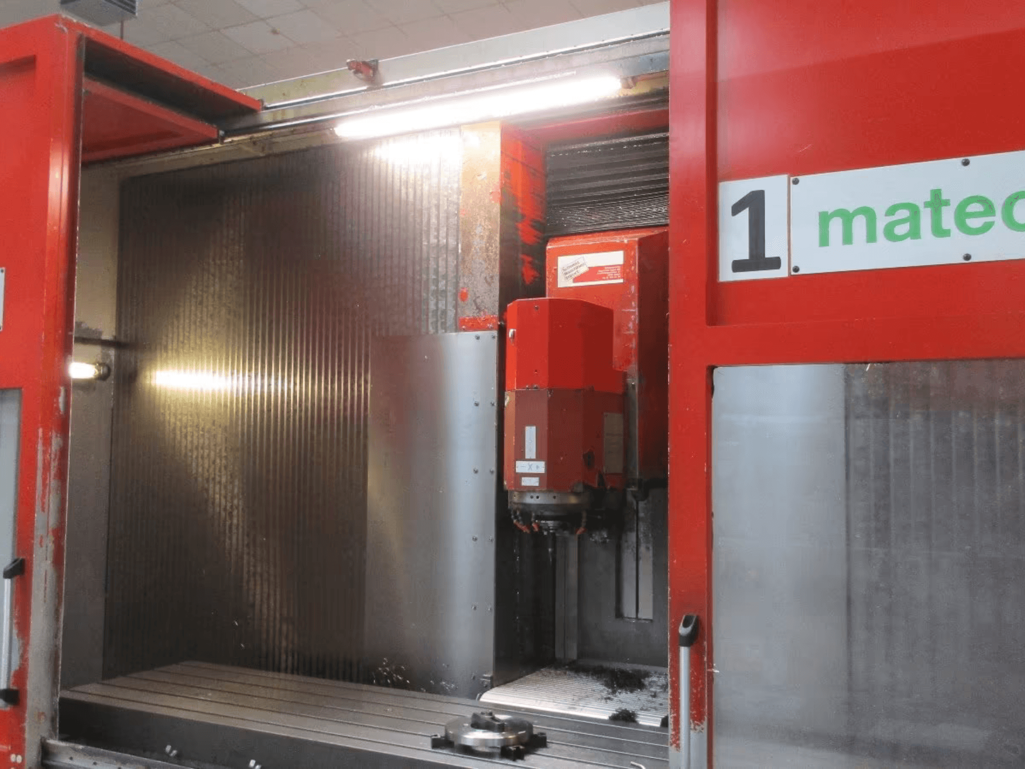 Matec 30 HV CNC vertikaalse töötluskeskuse esiosa, kus on näha lõiketööriistad, metallpind ja masina sisemuse üksikasjad.