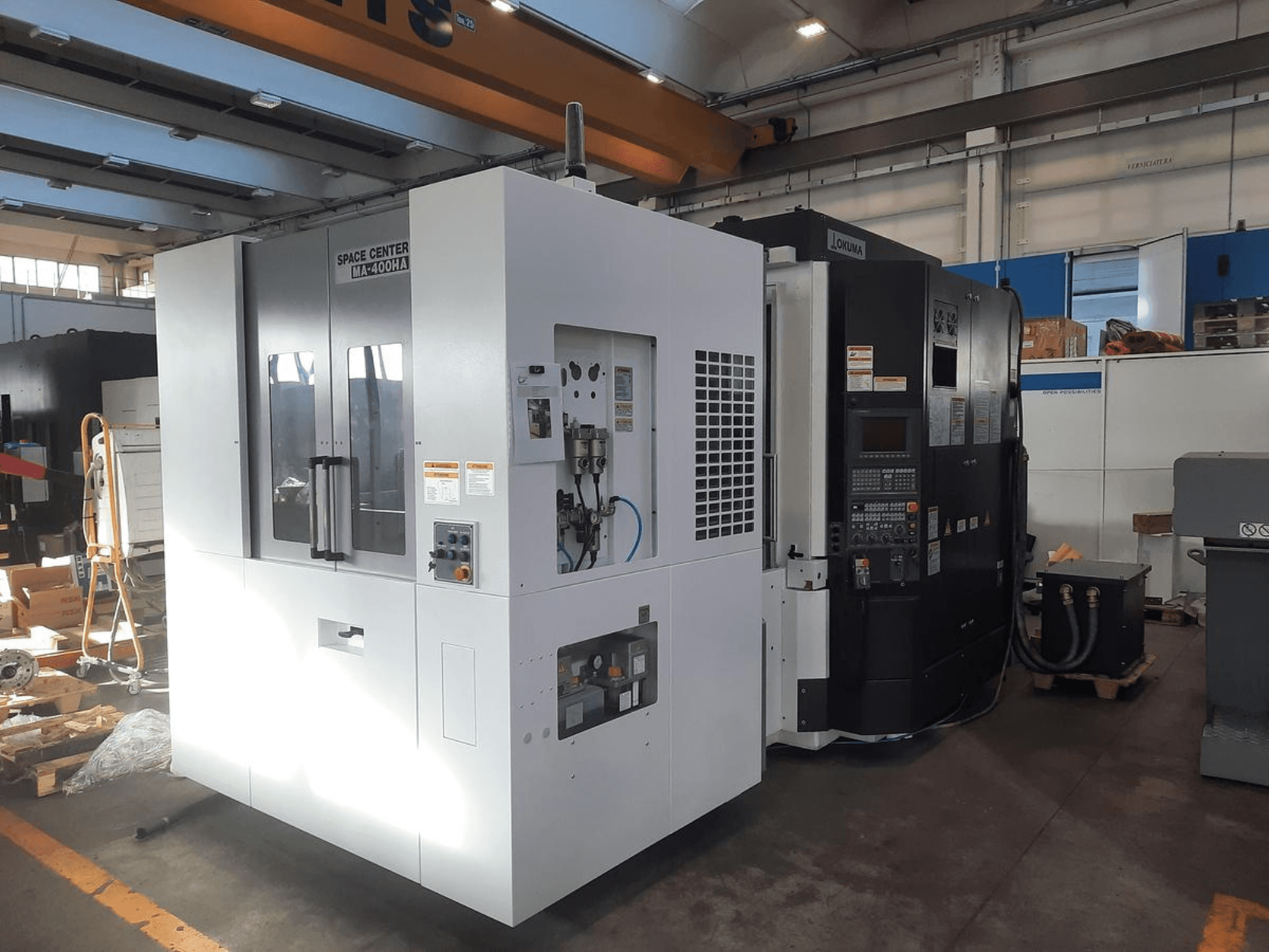 SPACE CENTER IM-400HAA ja OKUMA CNC-pinkide esikülg, millel on erinevad juhtimisseadmed ja tootja sildid.