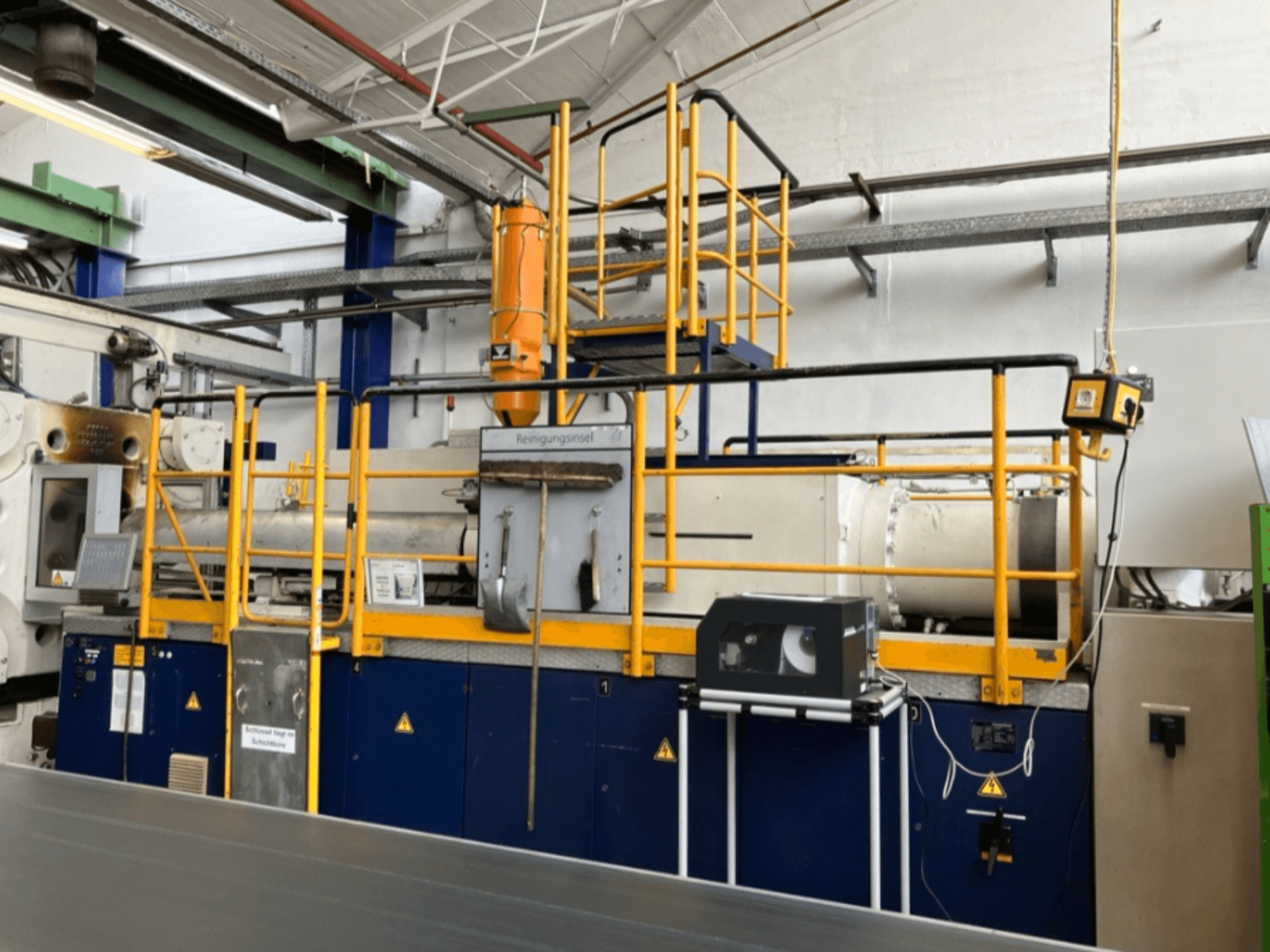 Krauss Maffei 1000-8000 M hüdrauliline survevalu masin, külgvaade, kus on näha turvakaitseraudtee ja juhtpaneel.