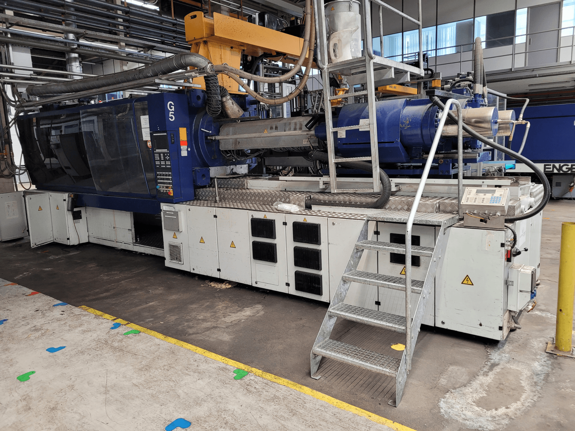 Süstevalu masin G5, külgvaade, juhtpaneel, astmeline redel ja roostevabast terasest tööpind nähtavad.