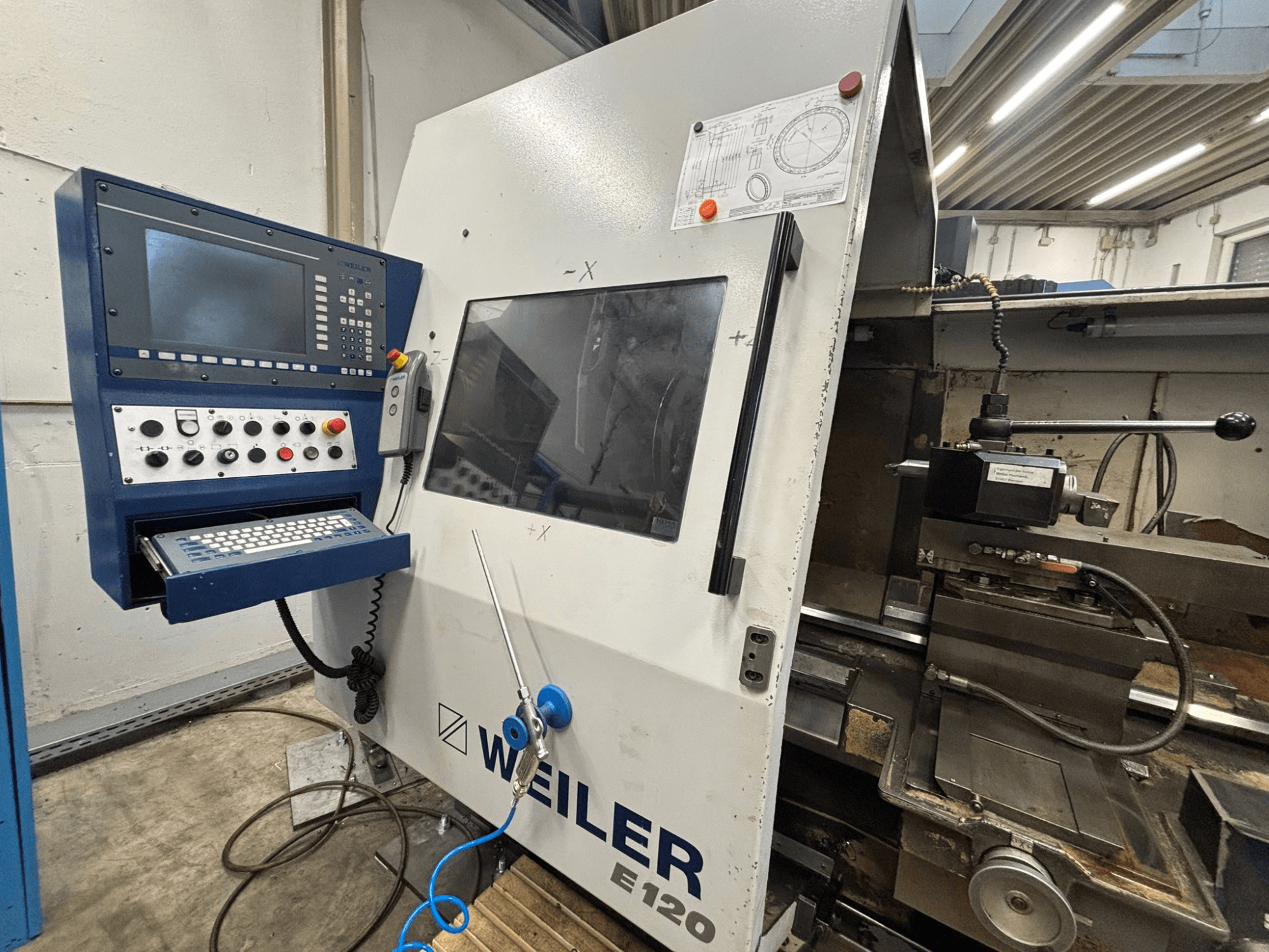 Weiler E-120 CNC masina juhtpaneel ja kasutajaliides, esiosa koos nähtavate nuppude, ekraani ja kasutuskomponentidega.