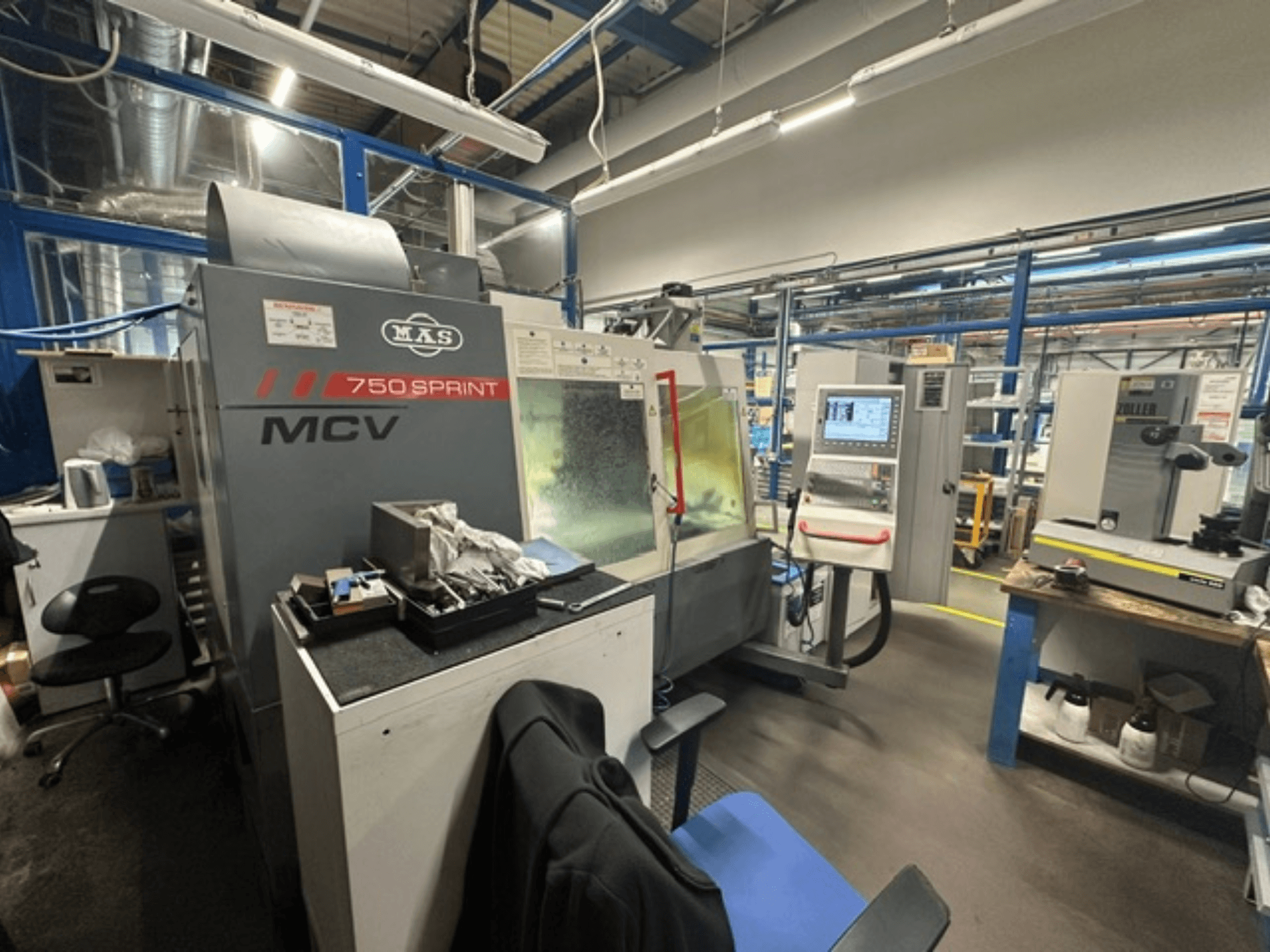 Töökojas asuv vertikaalne töötlemiskeskus KOVOSVIT MAS MCV 750 Sprint, millel on külgvaates näha juhtpaneel ja tööala.