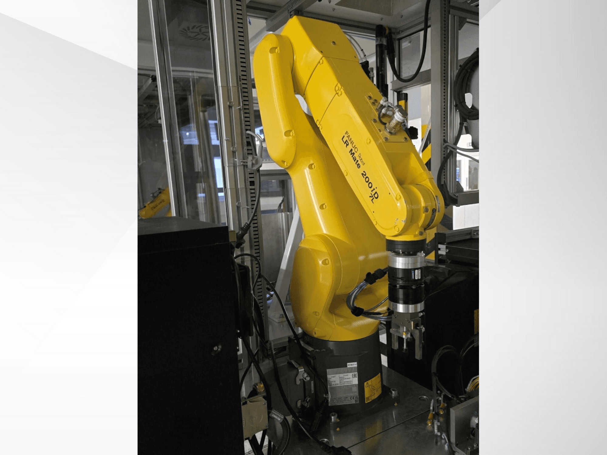Kollane Fanuc LR Mate 200iD robotkäsi külgvaates, millel on haarats ja mitmesugused kinnitatud kaablid.