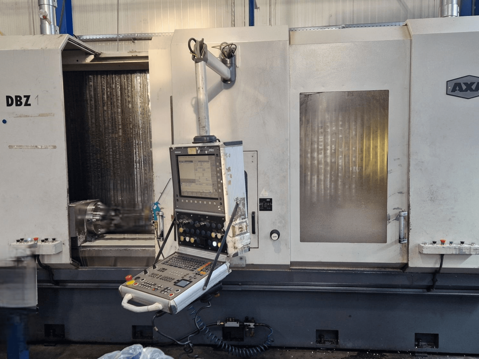 AXA DBZ vertikaalne töötluskeskus, mis on kujutatud nurga all esiplaanilt, kus on juhtpaneel ja nähtav lõiketööriistade ala.
