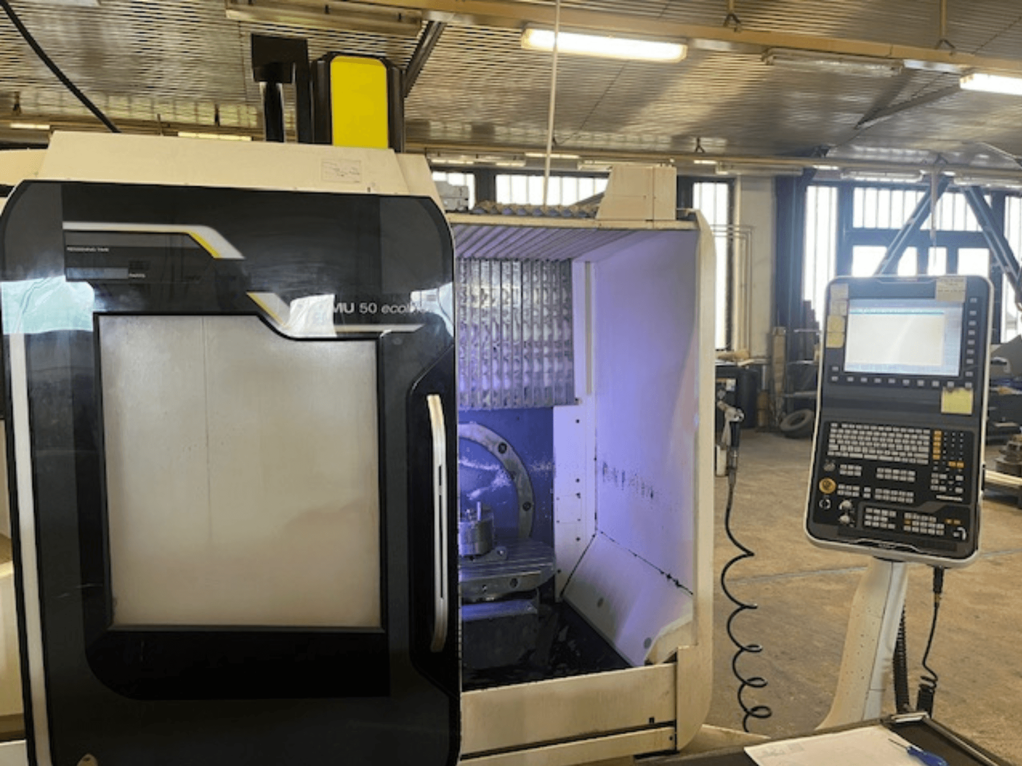 DMU 50 eco freespingi esikülg koos juhtpaneeliga, millel on tööriistahoidja ja tööruum.