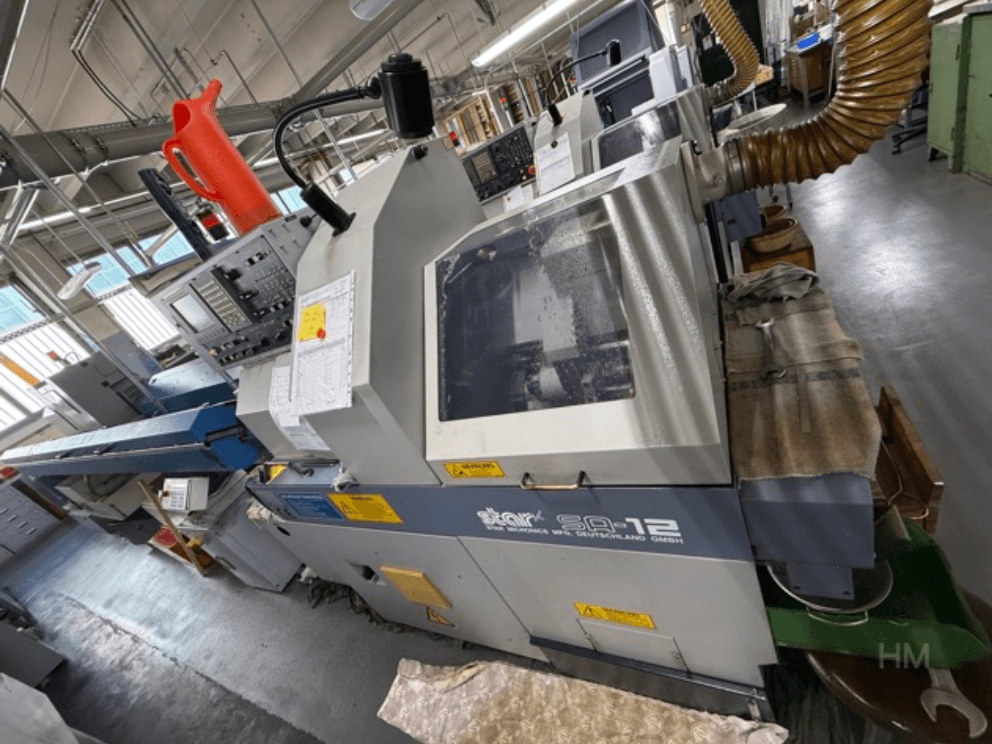 Star SQ-12 töötlemiskeskus, külgvaade, kus on näha juhtpaneel, jahutusvedeliku mahuti ja tolmueemaldusvoolik.