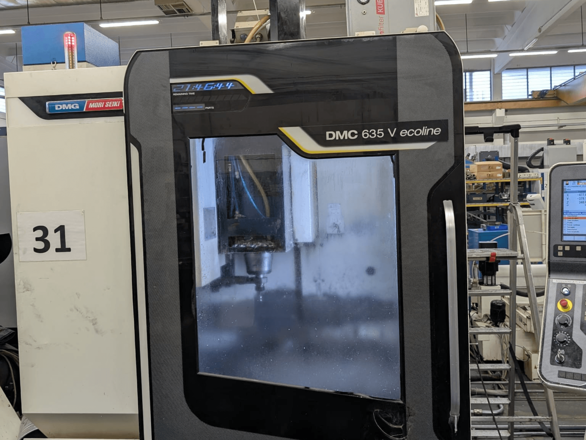 DMG Mori Seiki DMC 635V ecoline vertikaalne töötlemiskeskus, esiplaanil on juhtpaneel ja nähtav töötlemisala.