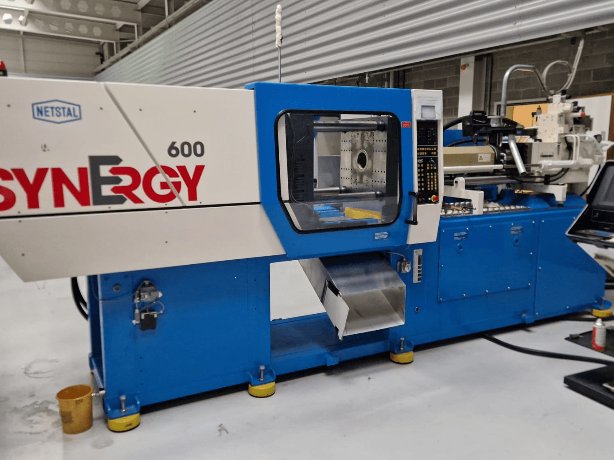 Netstal Synergy 600-230 hüdrauliline survevalu masin, külgvaates on näha juhtpaneel ja sissepritseala.