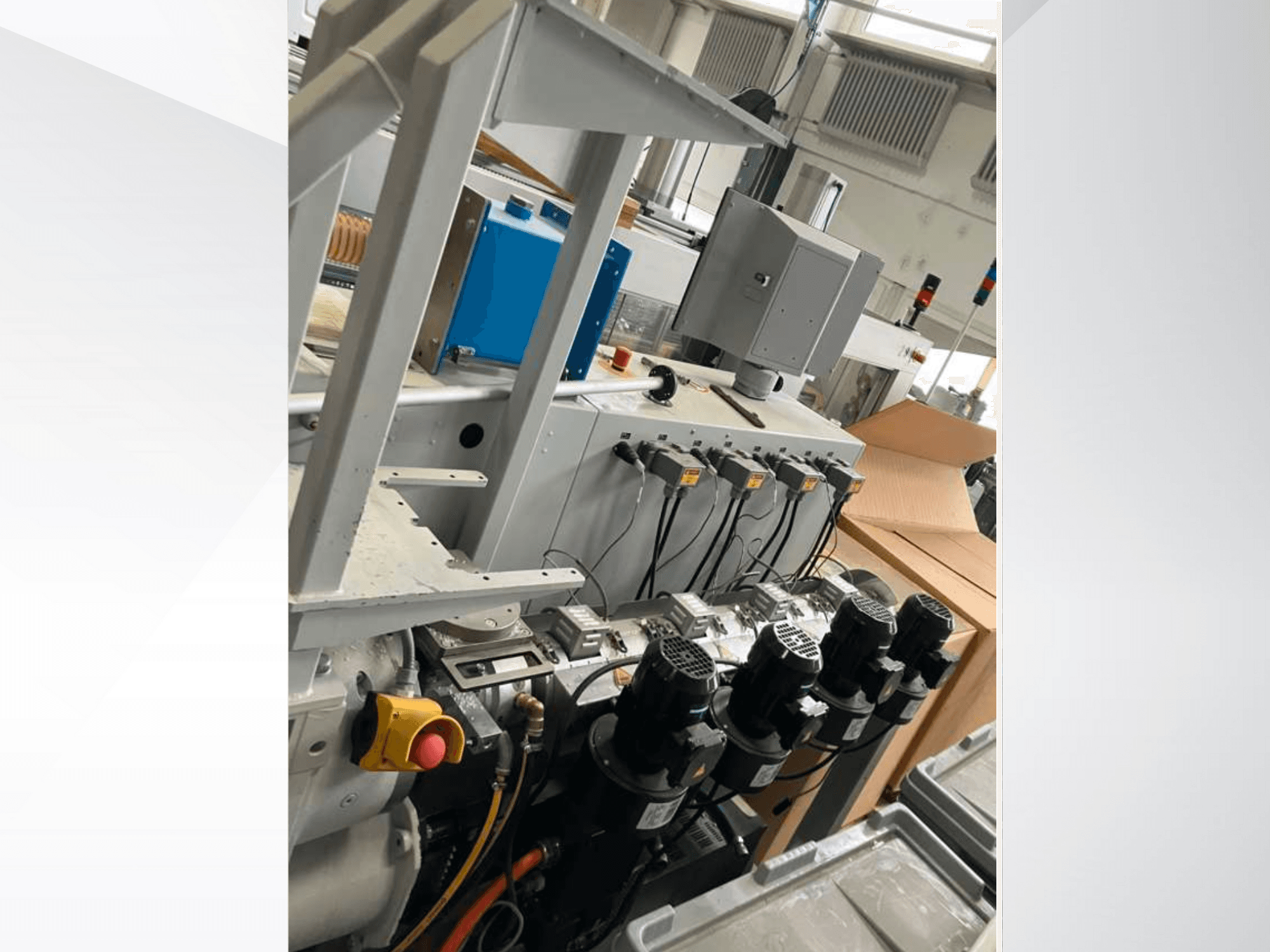 Tööstusmasinate juhtpaneel, millel on mitu mootorit, näidikud ja monitor; külgvaade tehases.