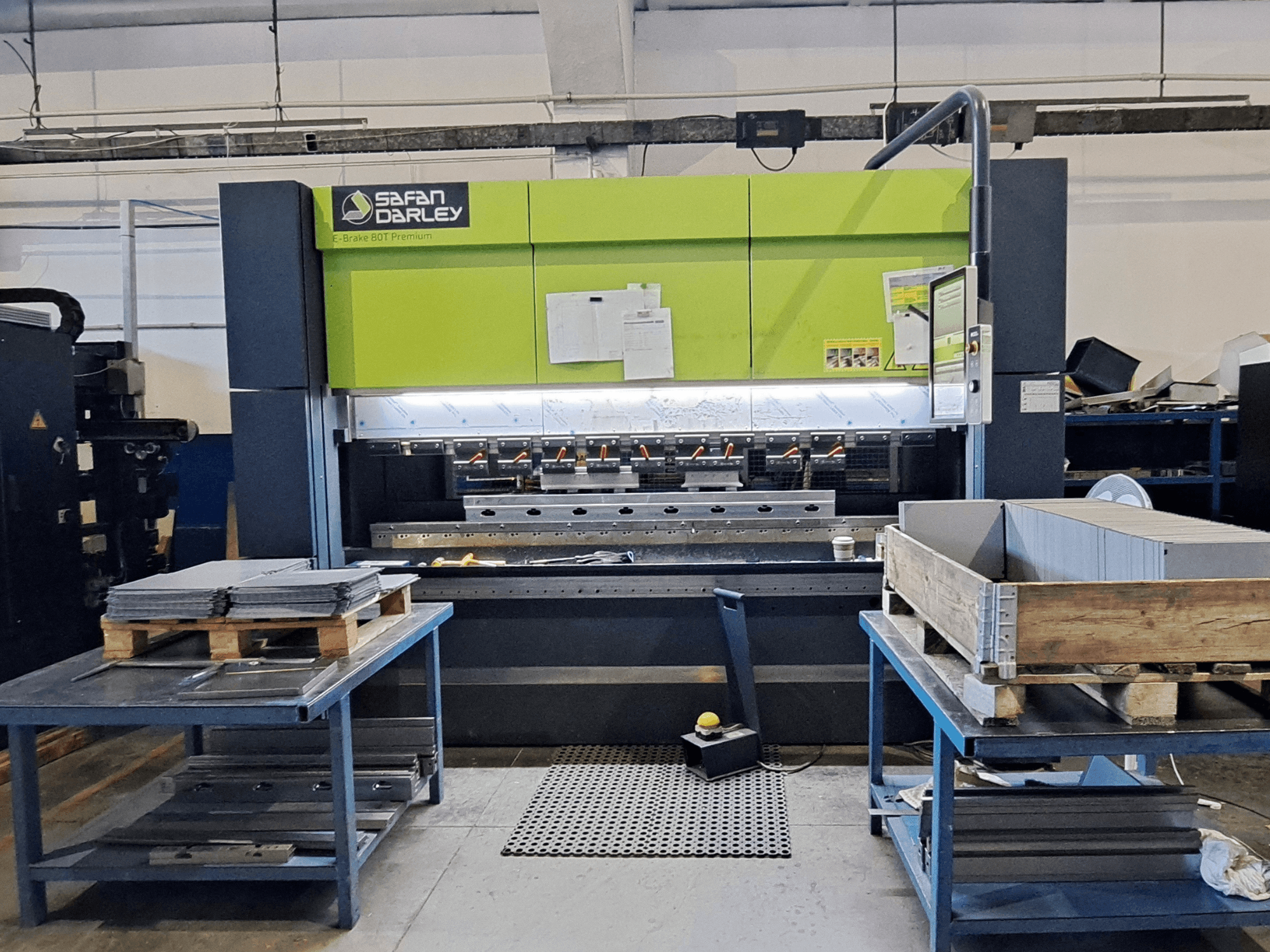 Töökojas asuv SAFAN E-Brake Premium 80-2550 painutuspress, vaade eest, kus on näha virna laotud metalllehed ja juhtpaneel.