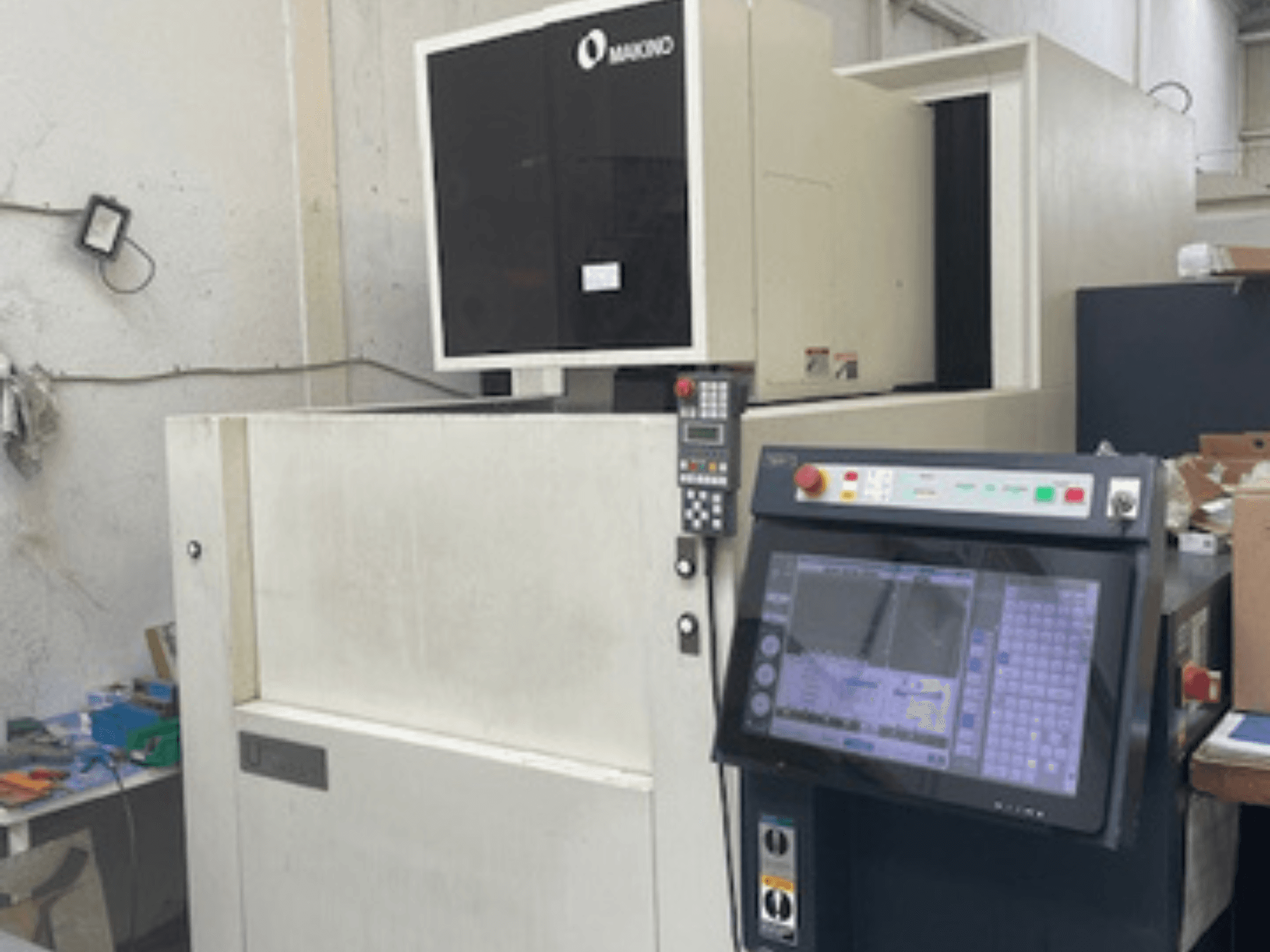 Makino U6 HEAT traadikeeramismasin töökojas, esiplaanil on juhtpaneel ja digitaalne ekraan.