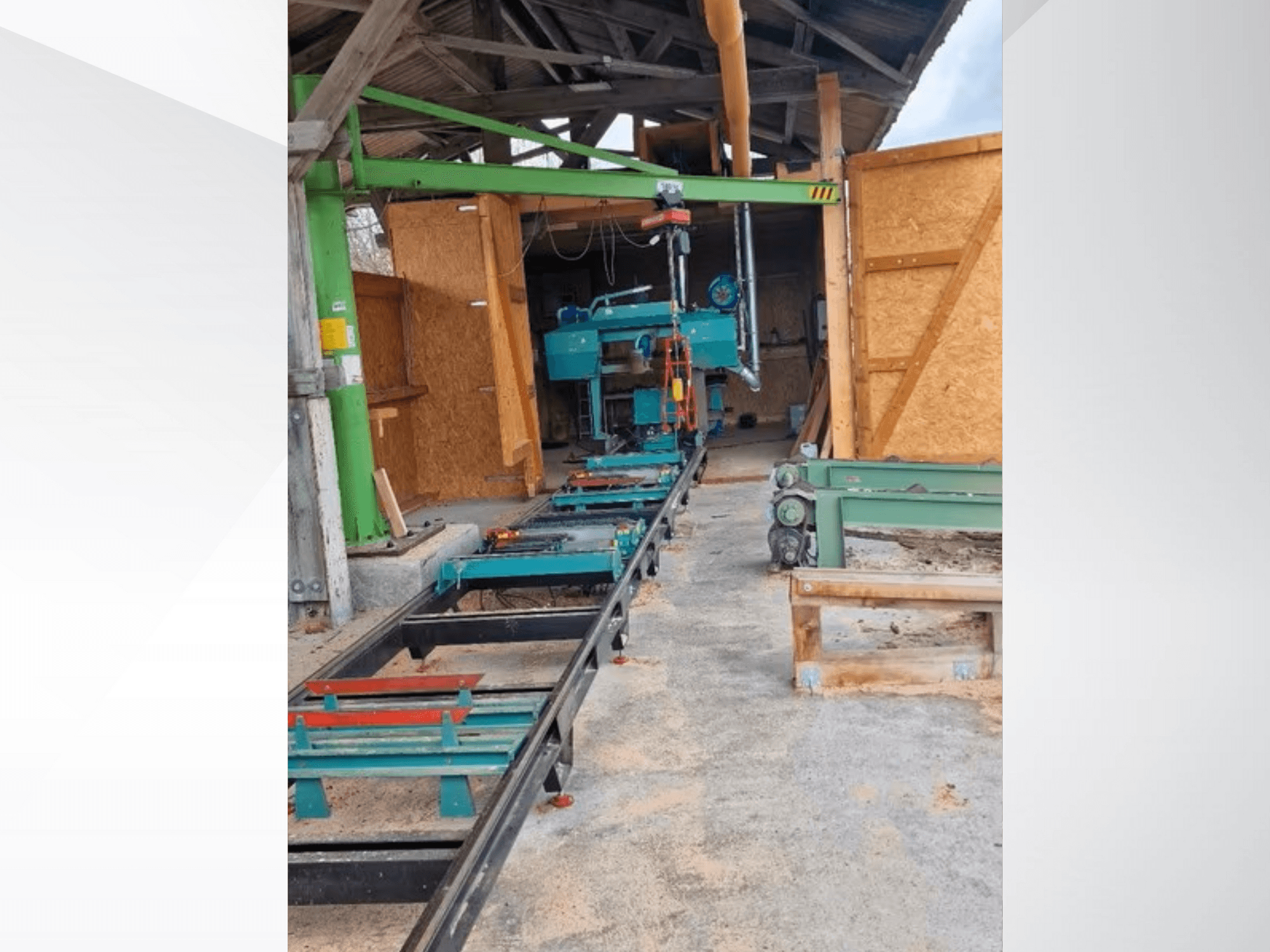 Horisontaalne saepink töökojas, vaadatuna eestpoolt. Seadme juurde kuuluvad rööbastee ja rohelised lisatarvikud.